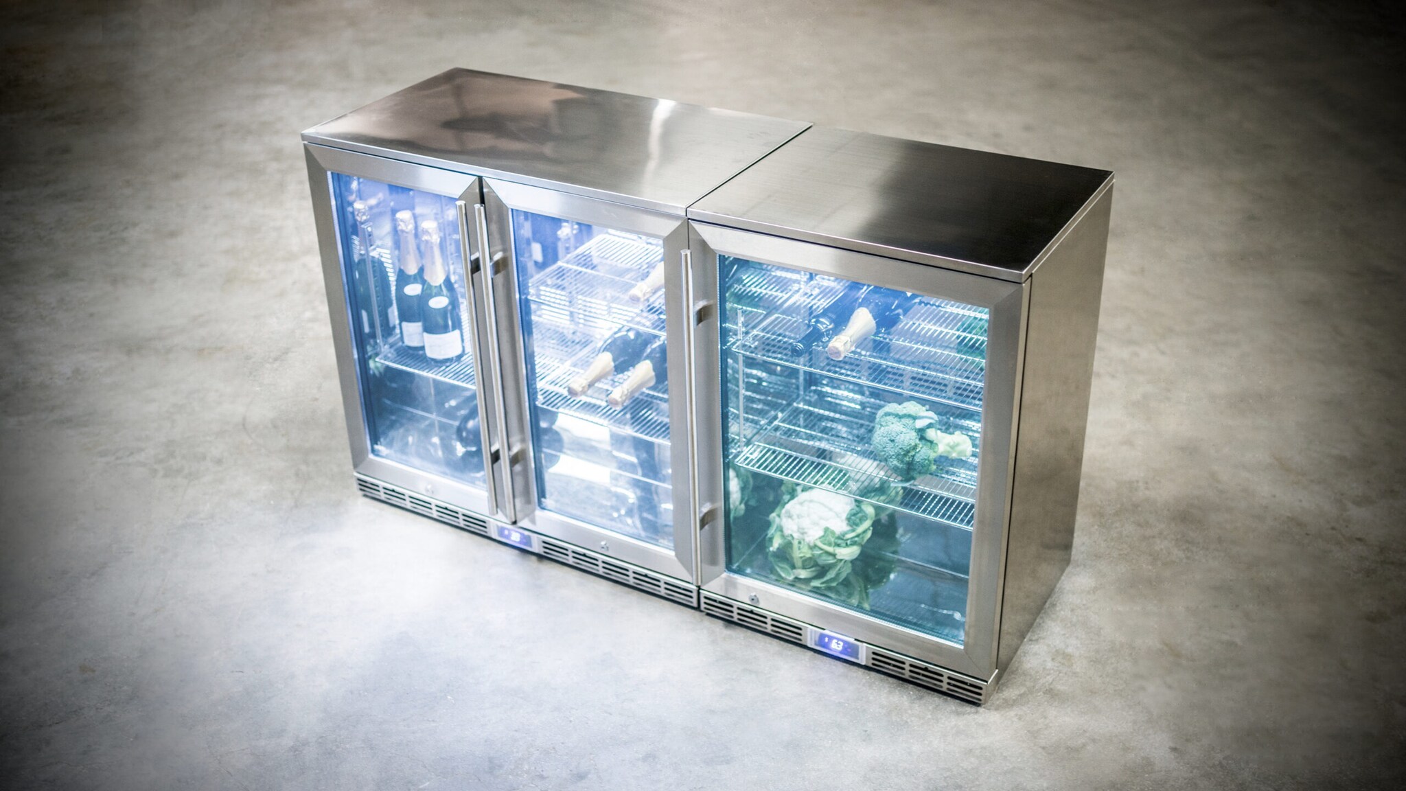 Ein Kühlschrank aus Edelstahl mit drei Glastüren Ein Kühlschrank aus Edelstahl mit drei Glastüren