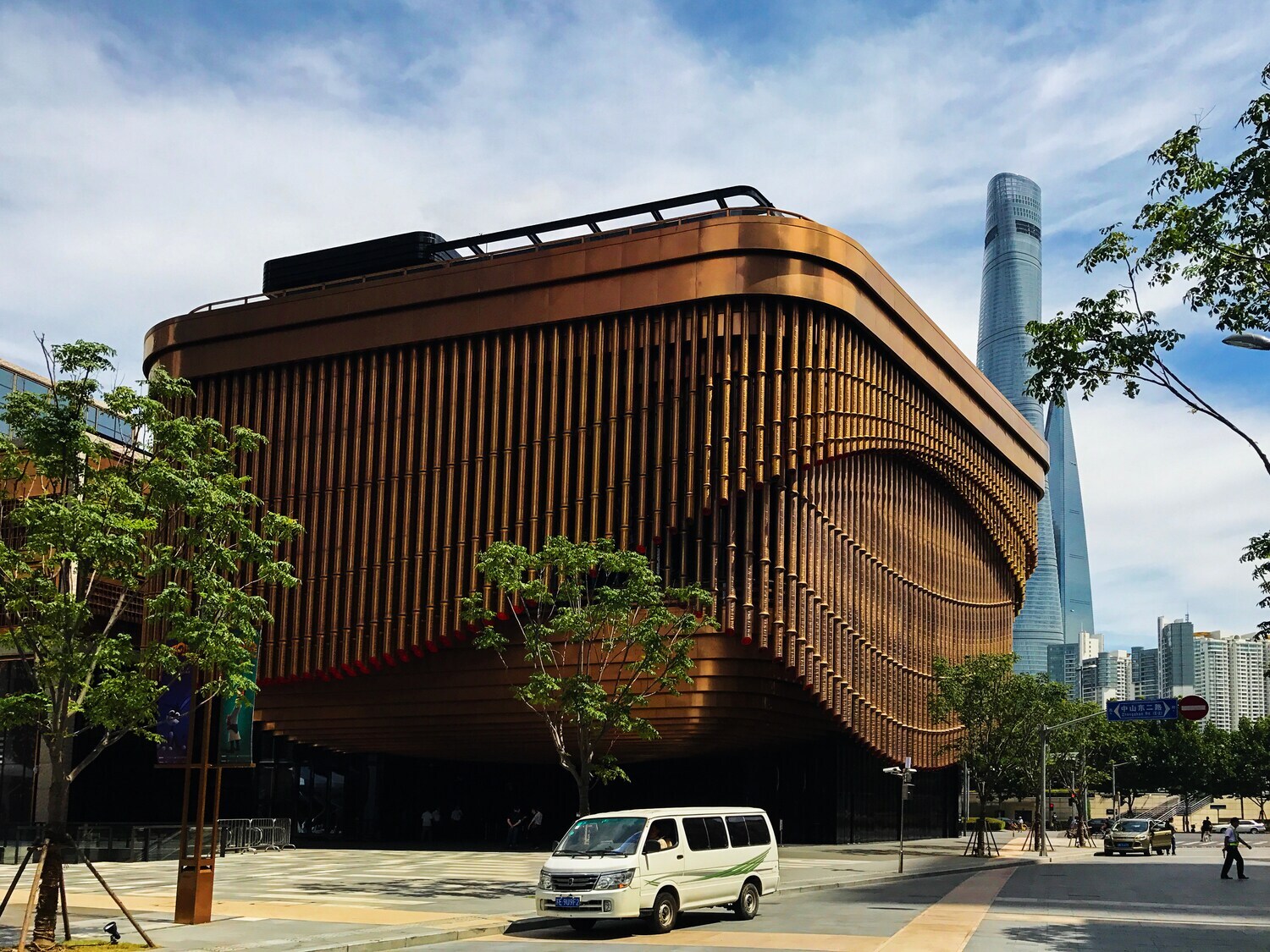 Modernes Gebäude mit Fassade aus beweglichen, goldfarbenen Stahlrohren im Zentrum von Shanghai
