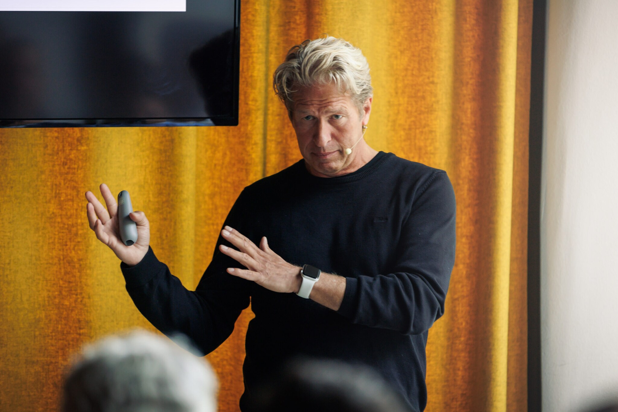 Oliver Leisse steht vor einer Gruppe von Menschen und hält einen Vortrag.