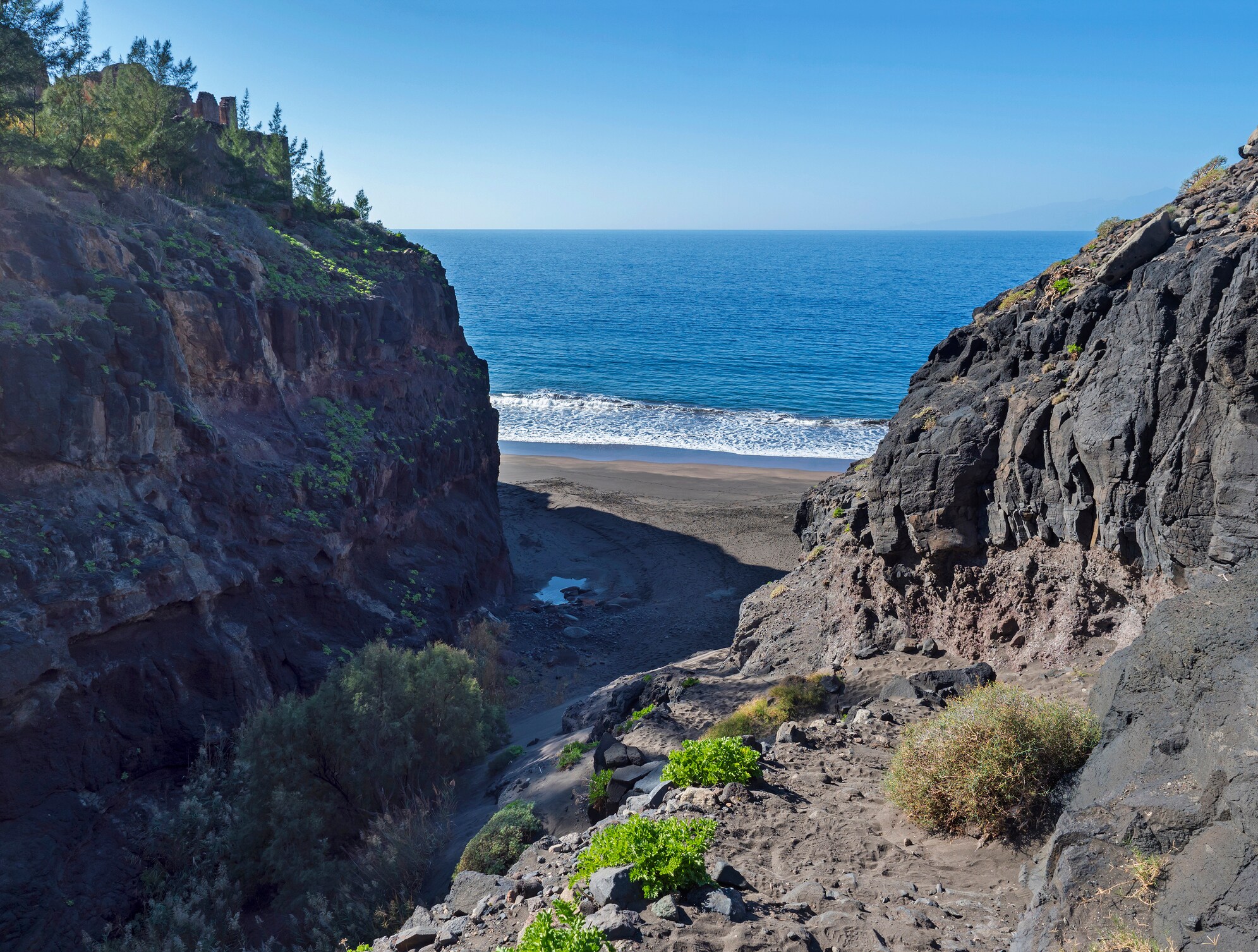 Mündung der Schlucht Barranco de Guigui Grande mit Blick auf den leeren Sandstrand Playa de Guigui im Westen der Insel Gran Canaria