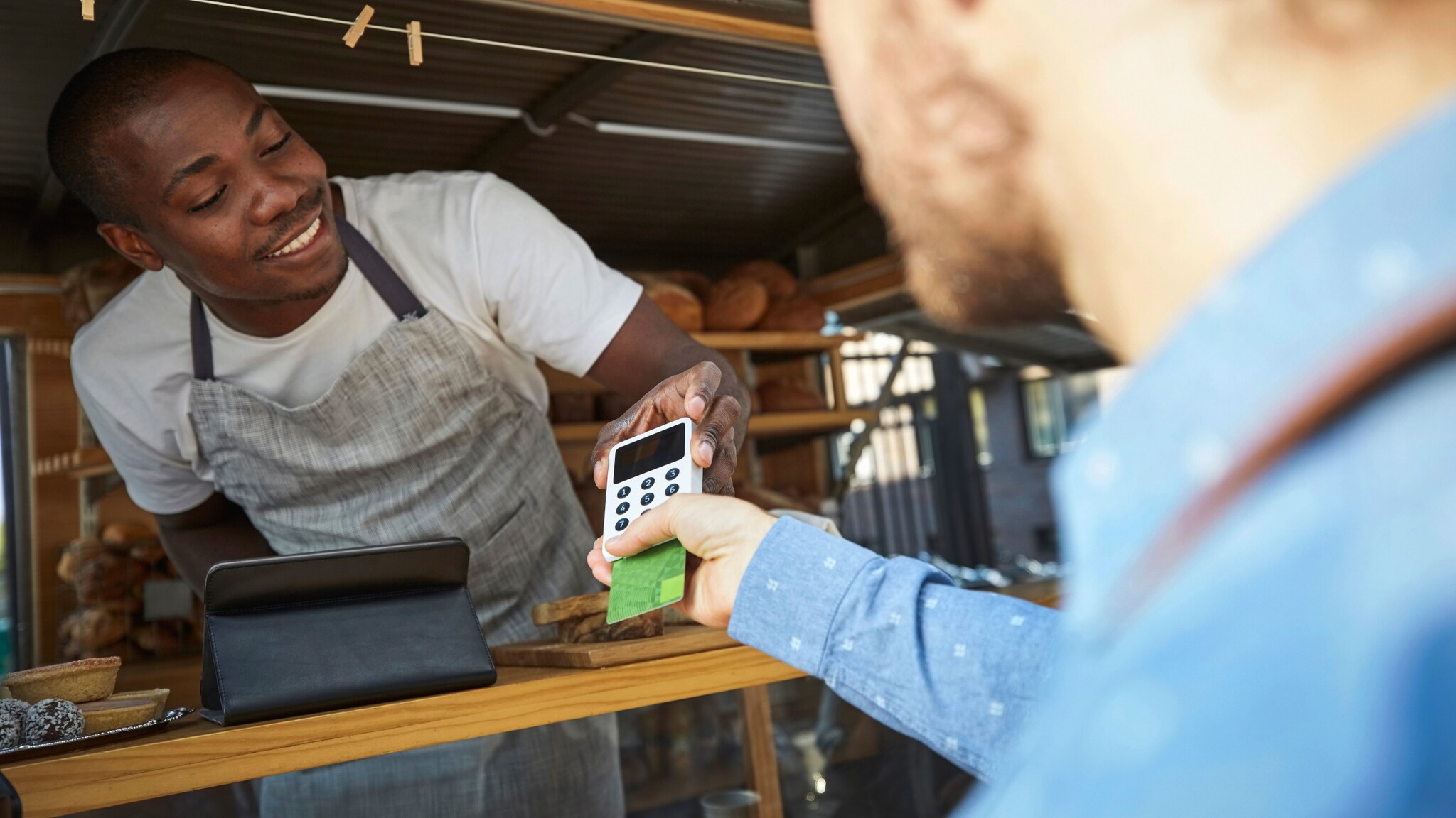 Zahlung mit Kreditkarte bei einem Verkäufer in einem Food Truck. Zahlung mit Kreditkarte bei einem Verkäufer in einem Food Truck.