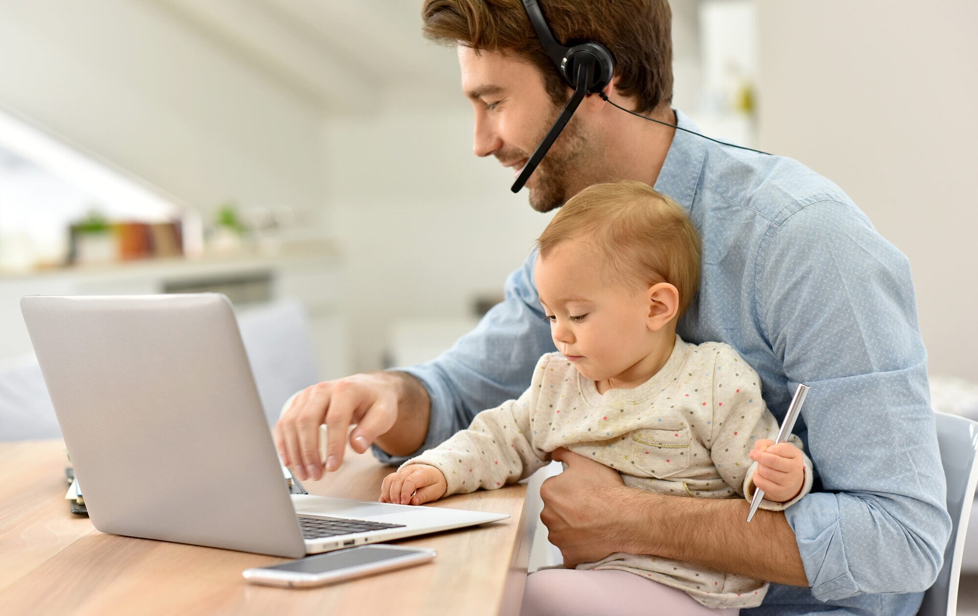 15_inline_image_home-office-typen_1 Busy businessman working from home and watching baby