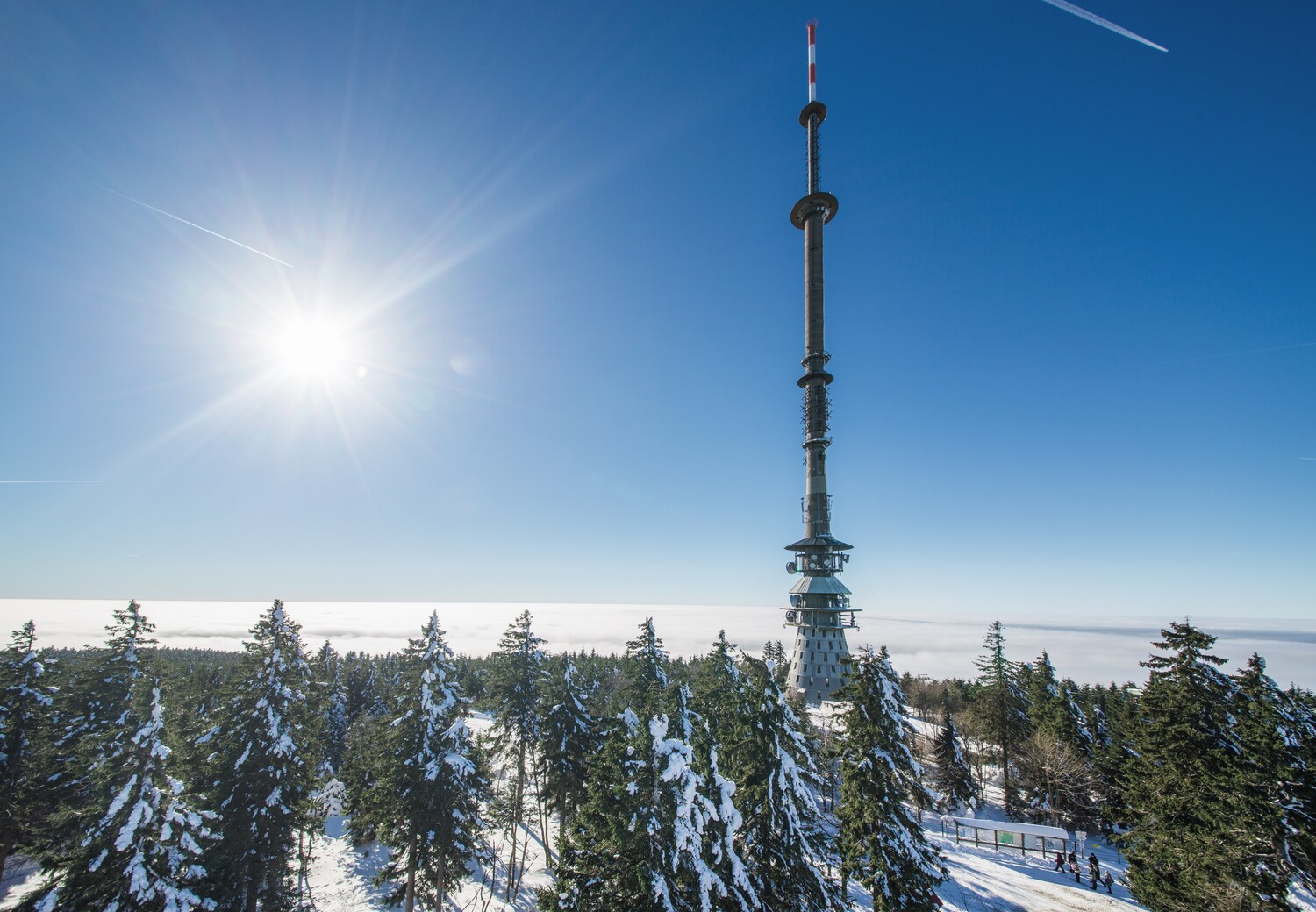 Bergspitze mit Turm und verschneiten Nadelbäumen