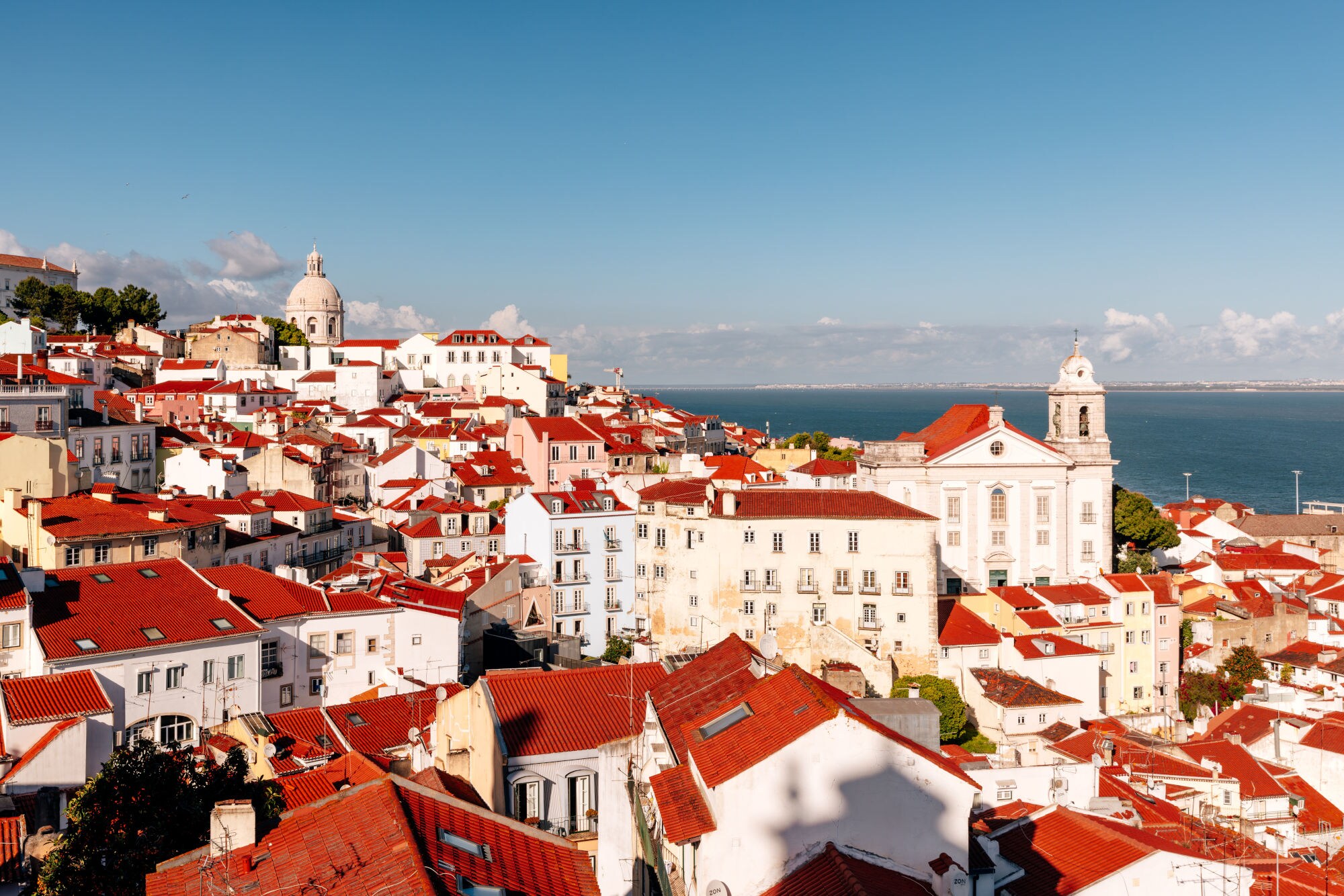 Blick auf die weißen Häuser mit ihren rotleuchtenden Dächern in Lissabons Altstadtviertel Alfama. Blick auf die weißen Häuser mit ihren rotleuchtenden Dächern in Lissabons Altstadtviertel Alfama.