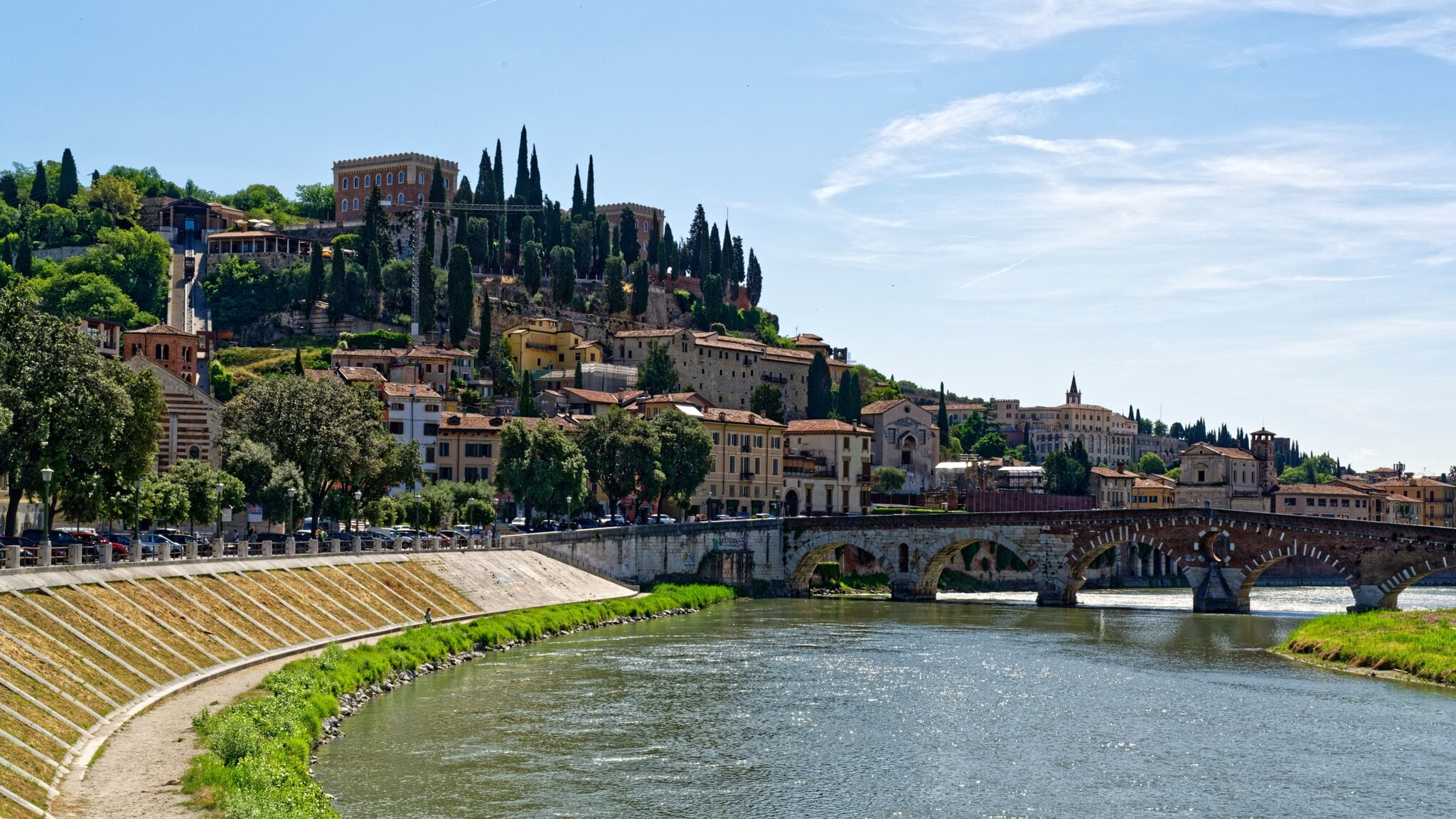 Italienische Stadt auf einem Hügel mit Zypressen an einem Fluss mit Bogensteinbrücke. Italienische Stadt auf einem Hügel mit Zypressen an einem Fluss mit Bogensteinbrücke.