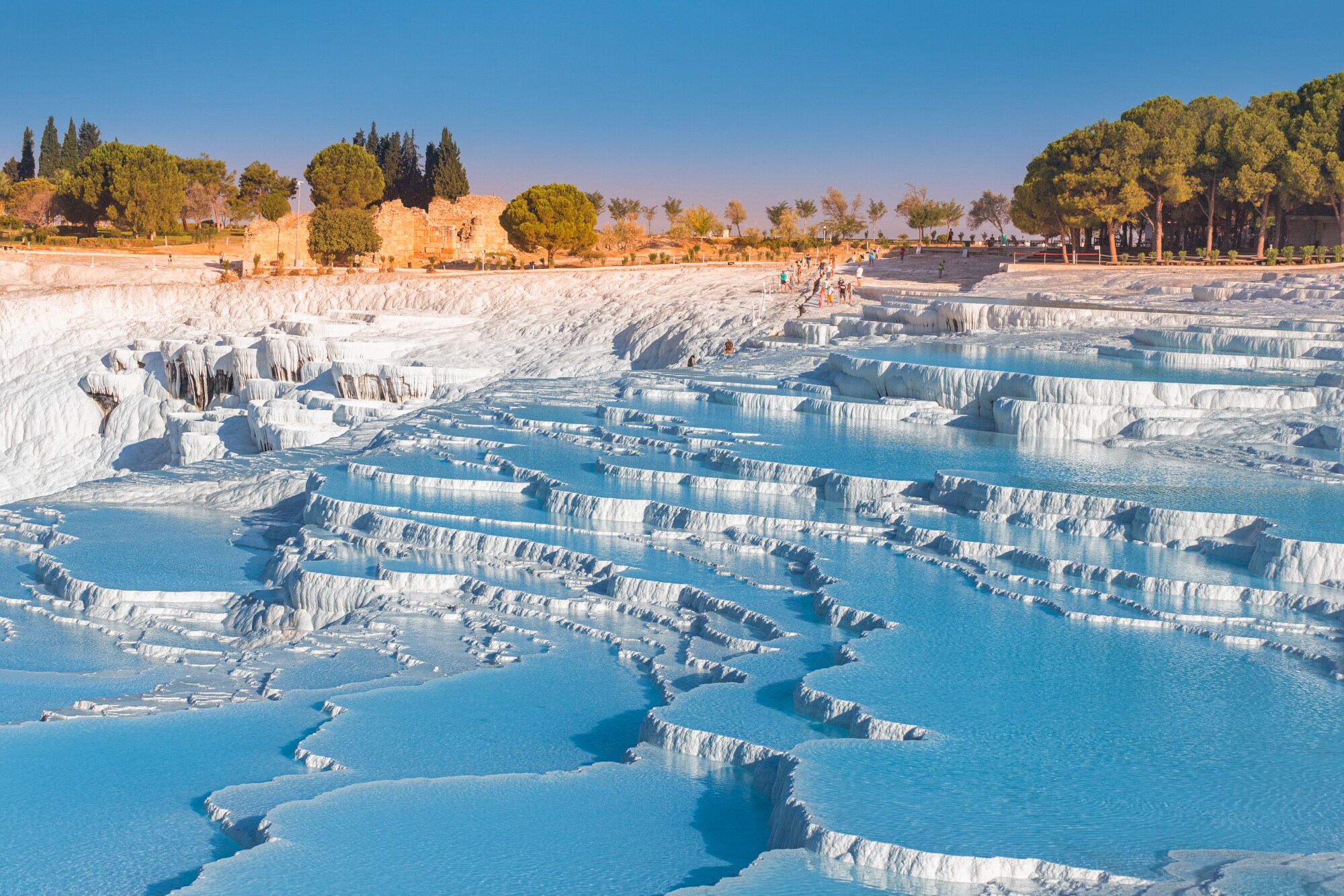 Besucher vor mit Wasser gefluteten Kalkterrassen in Pamukkale.