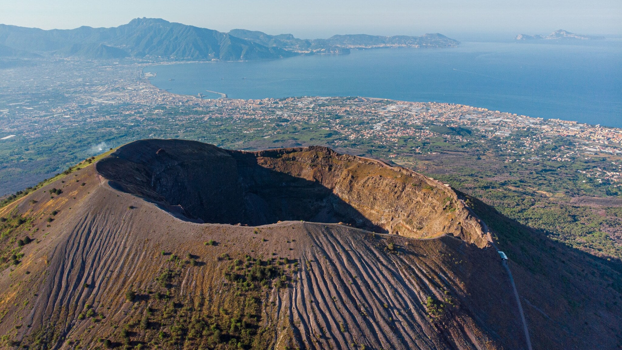 Luftaufnahme des Kraterrandes des Vesuvs mit Neapel und Meer im Hintergrund. Luftaufnahme des Kraterrandes des Vesuvs mit Neapel und Meer im Hintergrund.