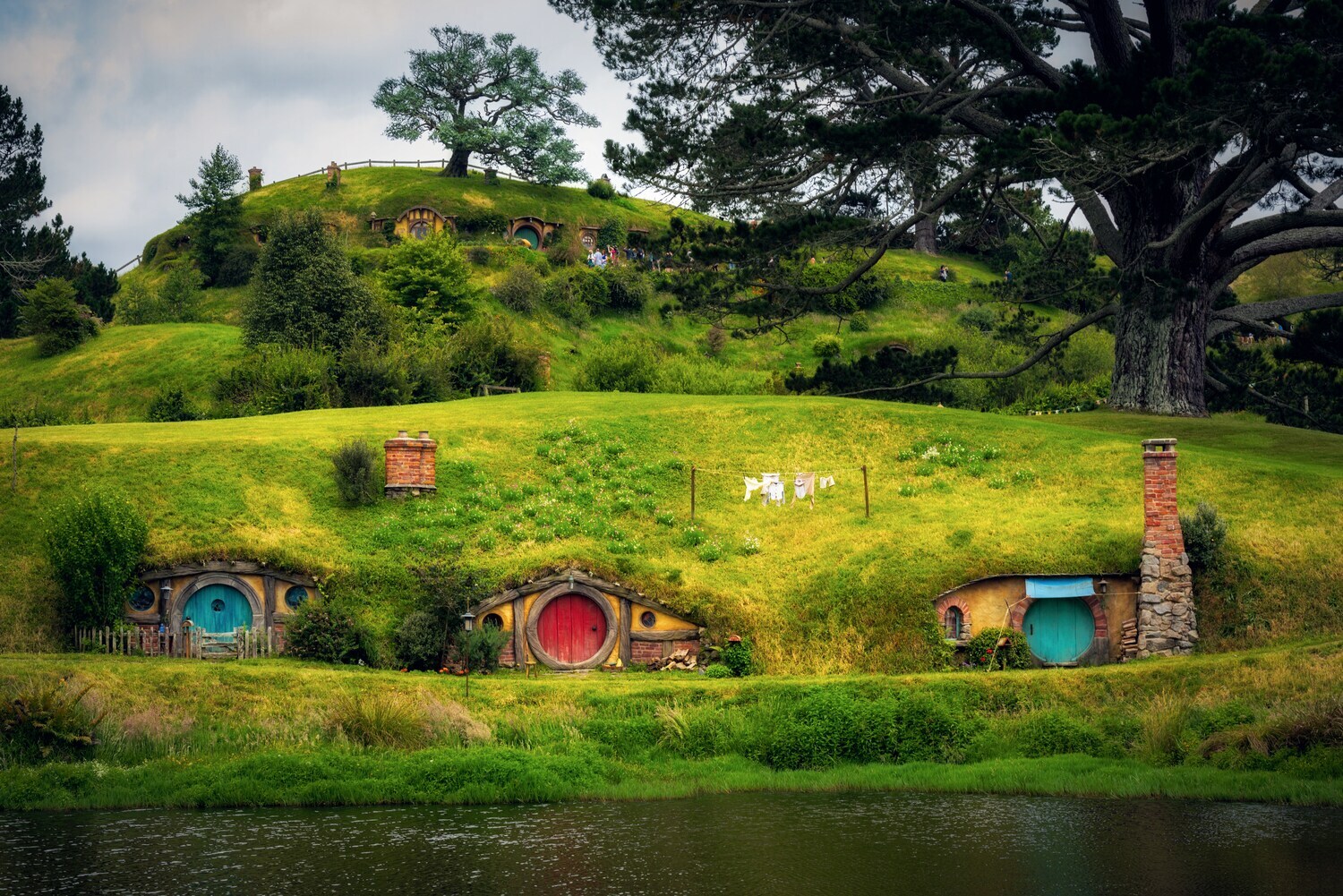 Idyllische Landschaft mit in begrünte Erdhügel gebaute Behausungen mit bunten Türen