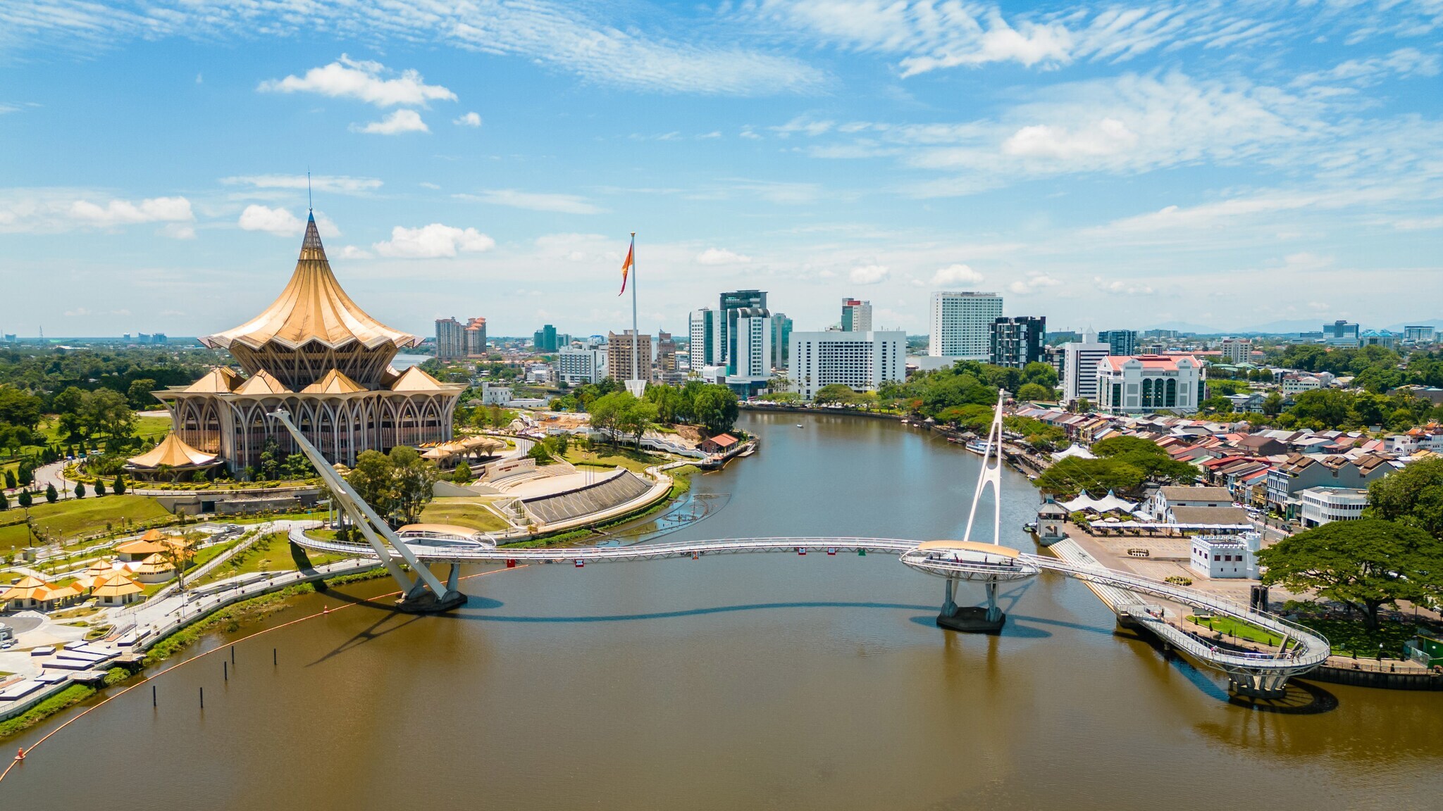 Panorama einer Stadt am Fluss mit Brücke und Palast mit goldenem Dach.