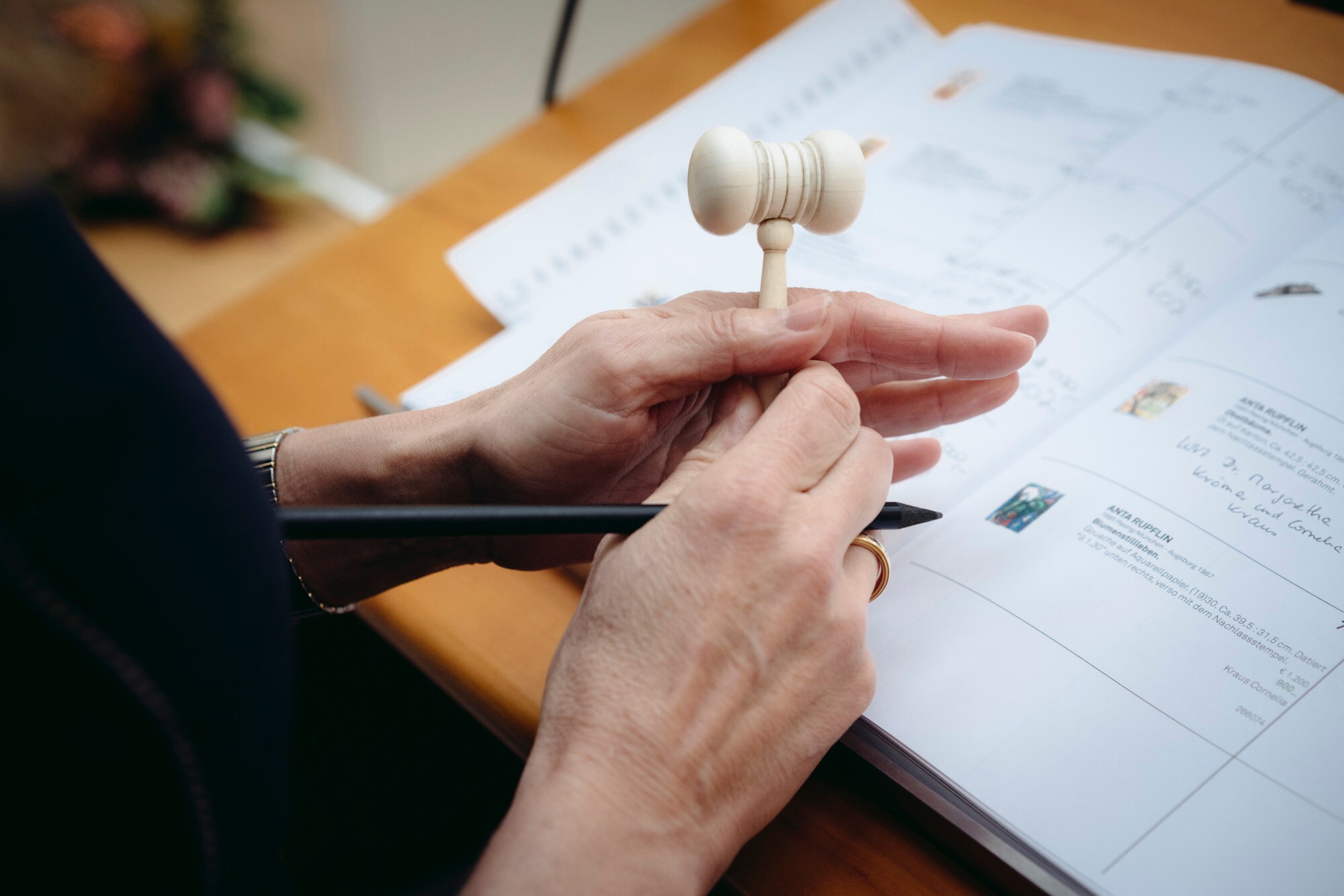 Eine Frau hält einen Auktionshammer.