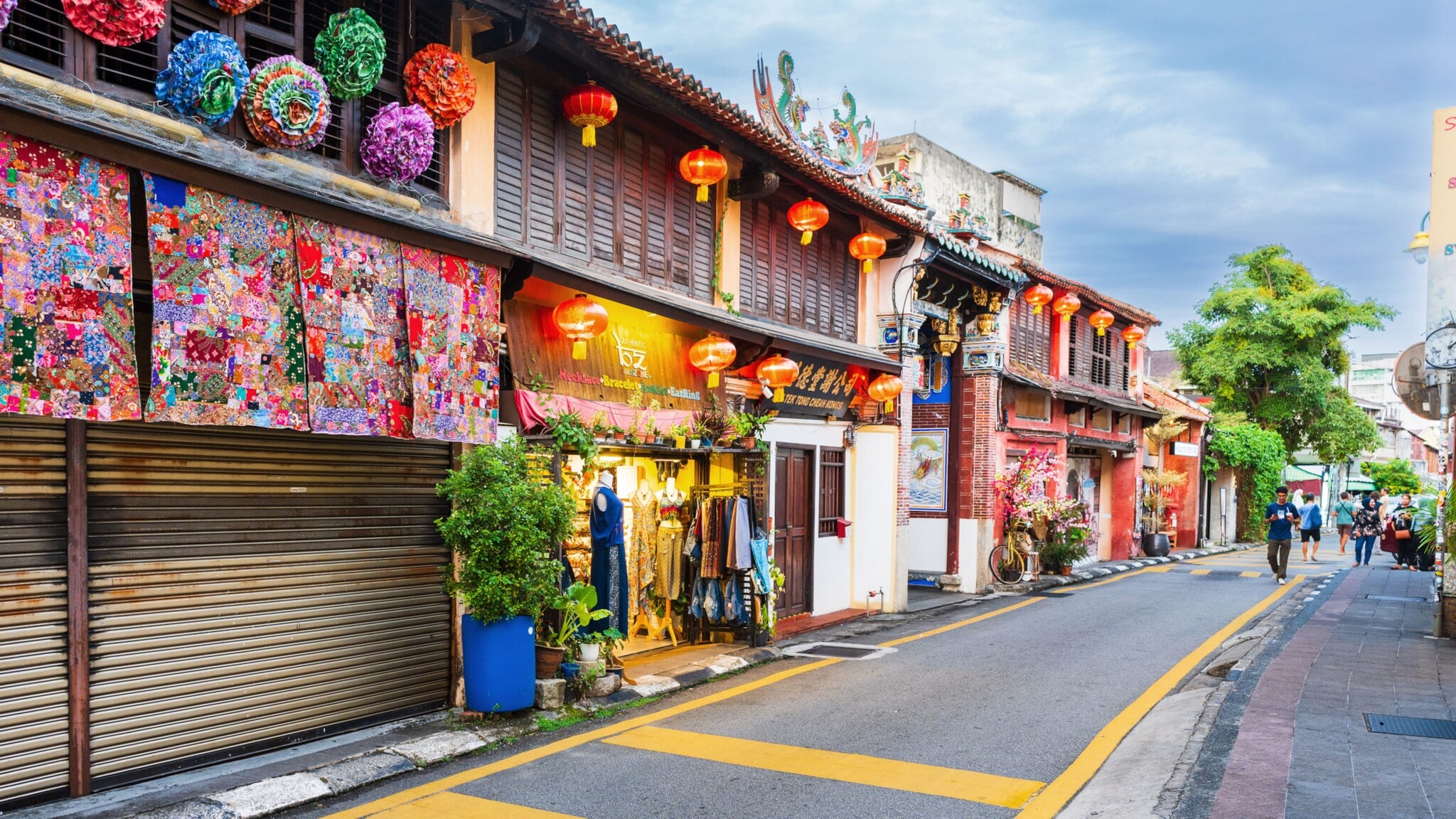 Schmale Straße mit Geschäften und roten Lampions um den Eingang zu einem chinesischen Tempel. Schmale Straße mit Geschäften und roten Lampions um den Eingang zu einem chinesischen Tempel.