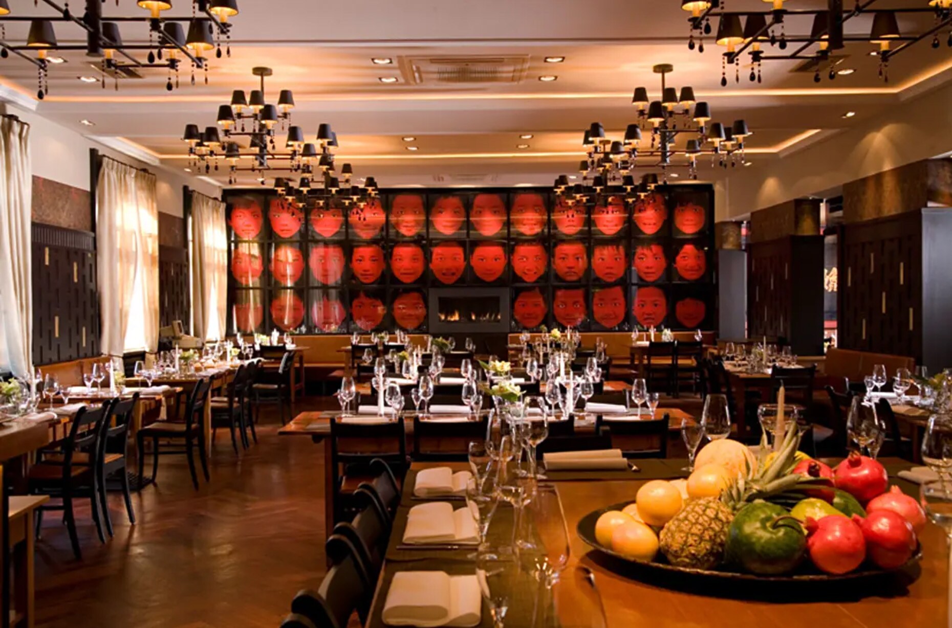 Innenraumaufnahme eines edlen, menschenleeren Restaurants mit gedeckten Tischen und asiatischen Designelementen Innenraumaufnahme eines edlen, menschenleeren Restaurants mit gedeckten Tischen und asiatischen Designelementen