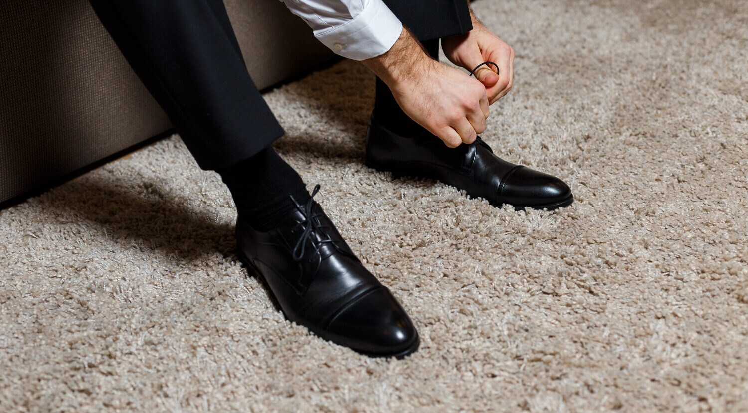 Mann schnürt schwarzen Derby Schuh