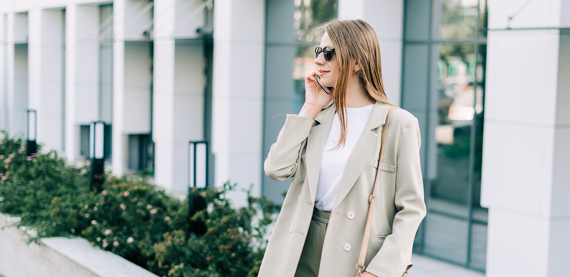 Business-Look im Sommer: So kommst du stylish durch die Hitzewelle Geschäftsfrau im Blazer telefoniert vor einem Bürogebäude