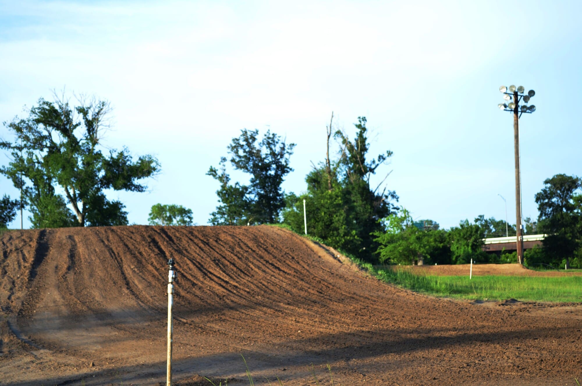 Ein Teil einer Motocross-Strecke, der einen Hügel zeigt Ein Teil einer Motocross-Strecke, der einen Hügel zeigt