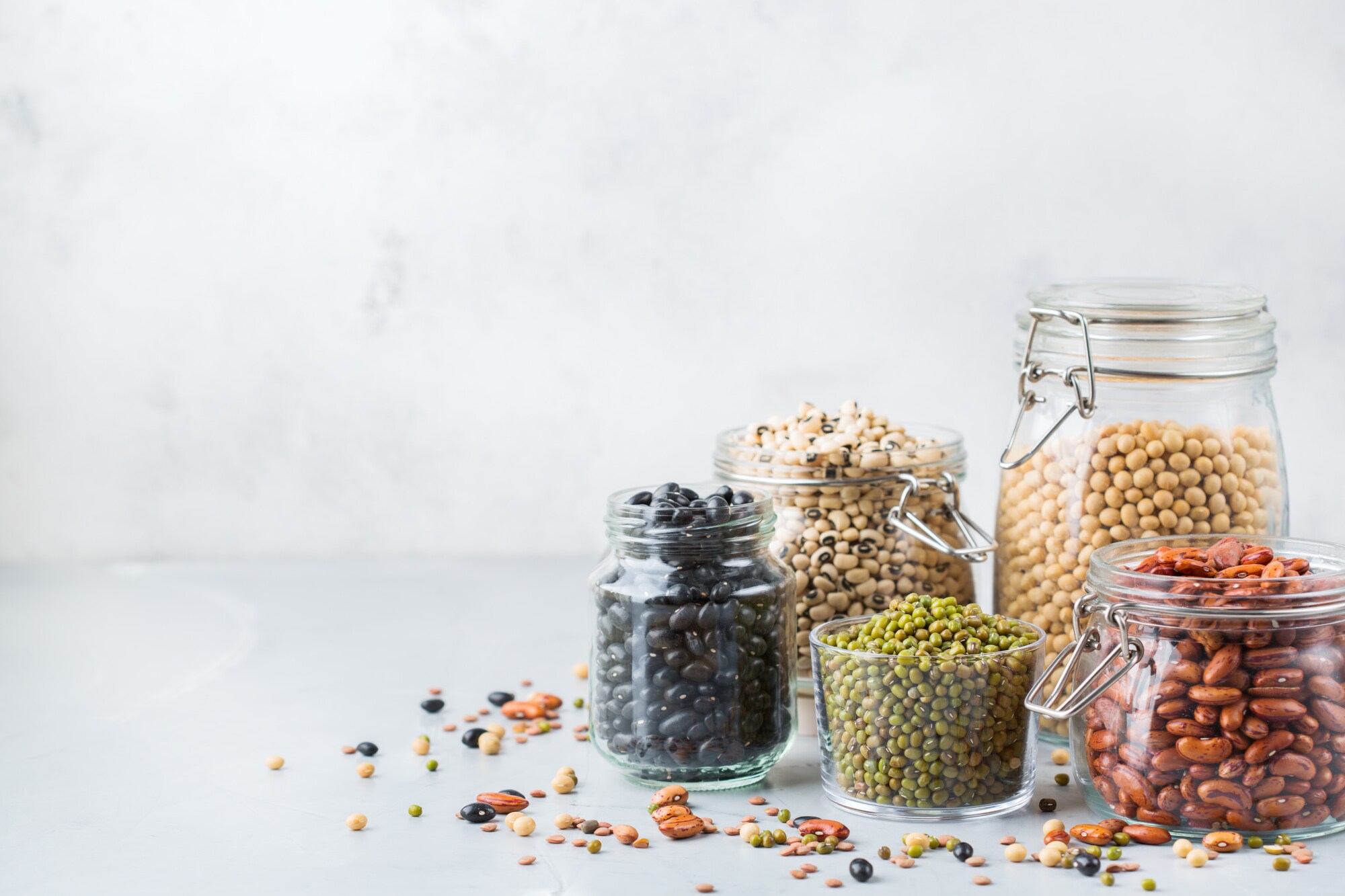 Auswahl an Hülsenfrüchten, Linsen, Kichererbsen und Bohnen in Gläsern