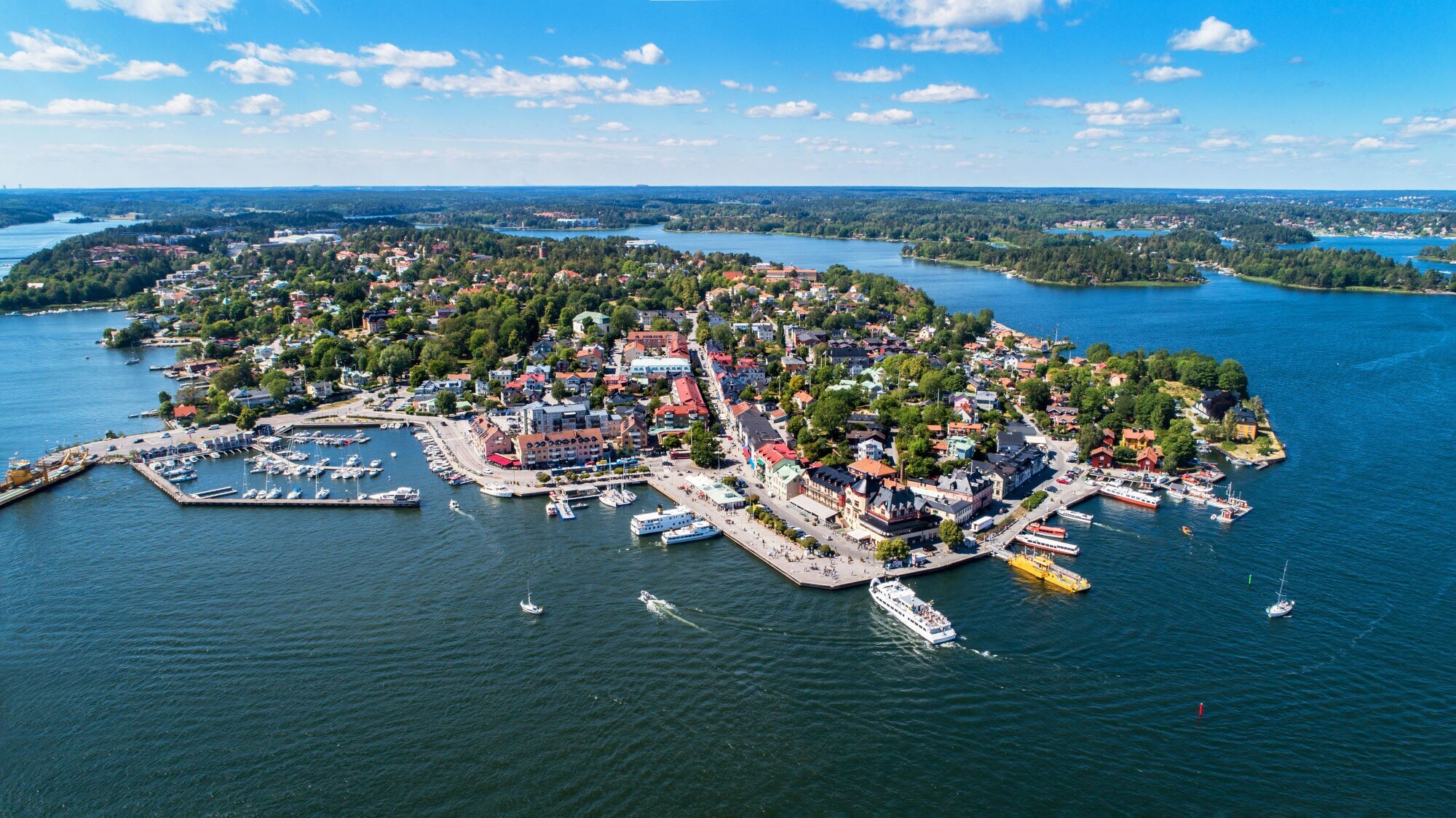 Ort mit Hafen auf einer Schäreninsel aus der Luftperspektive.