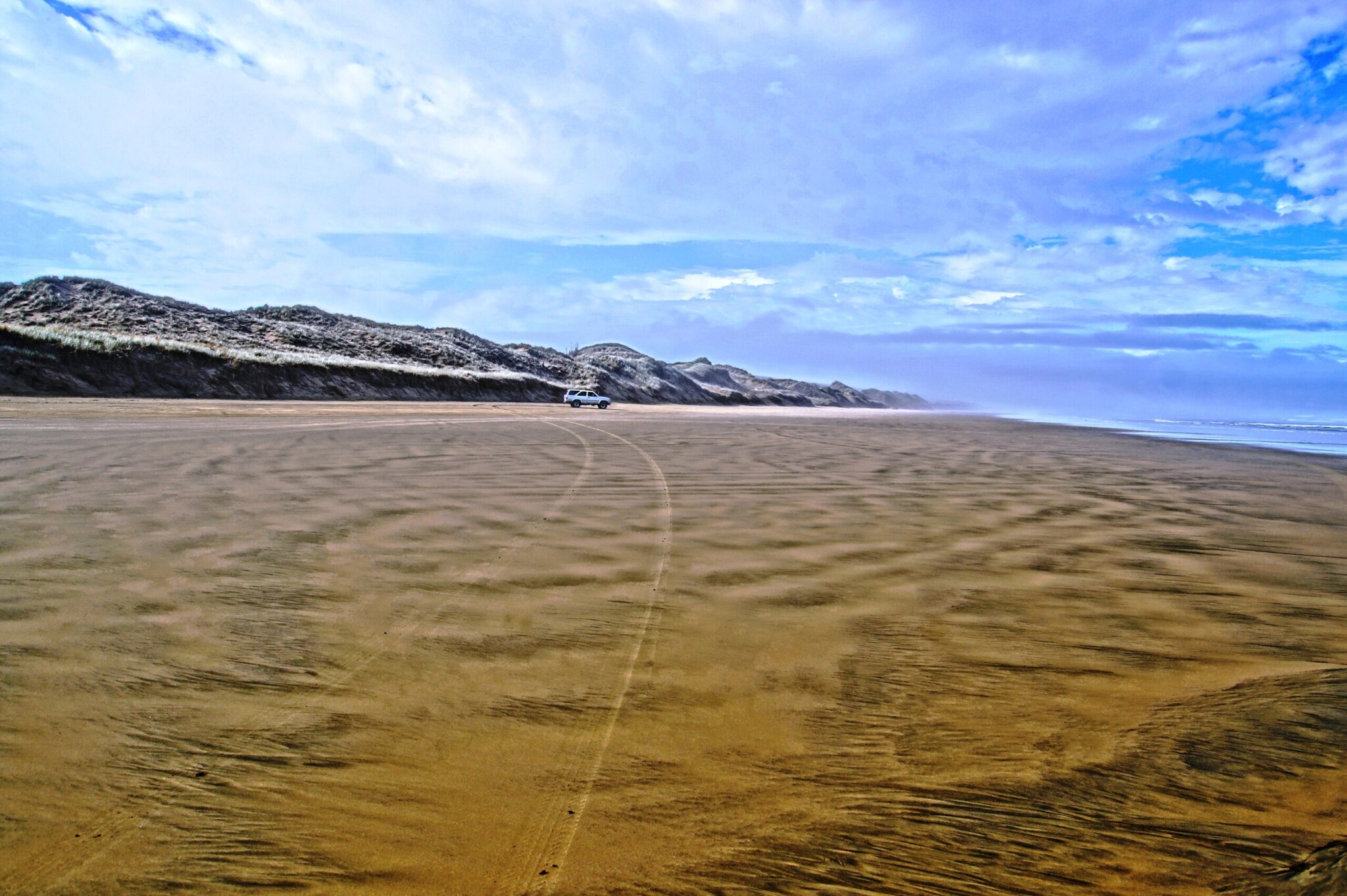 Ein Auto fährt auf dem Ninety Mile Beach. Ein Auto fährt auf dem Ninety Mile Beach.