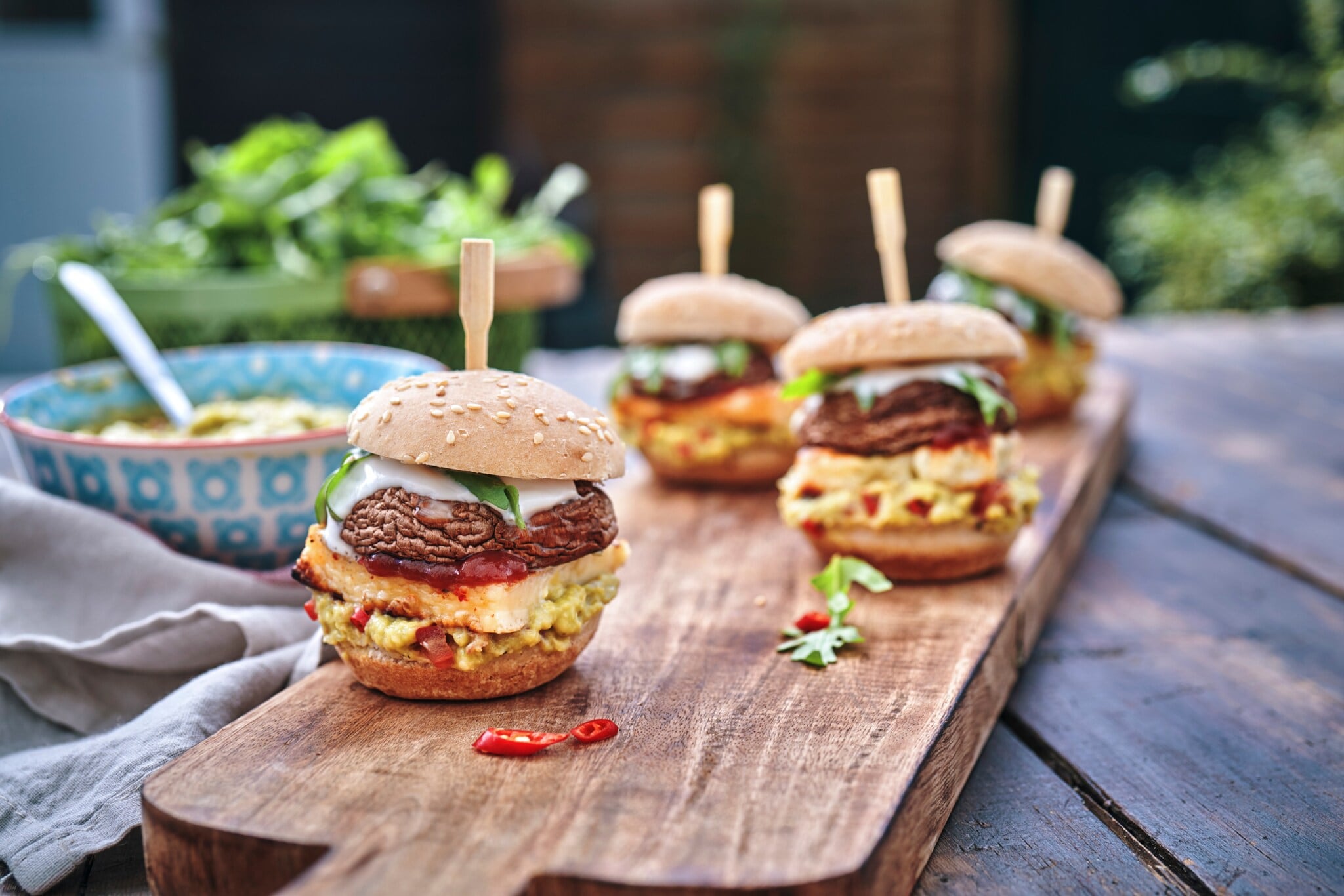 Kleine Burger mit Champignon-Pattys auf einem Brett. Kleine Burger mit Champignon-Pattys auf einem Brett.
