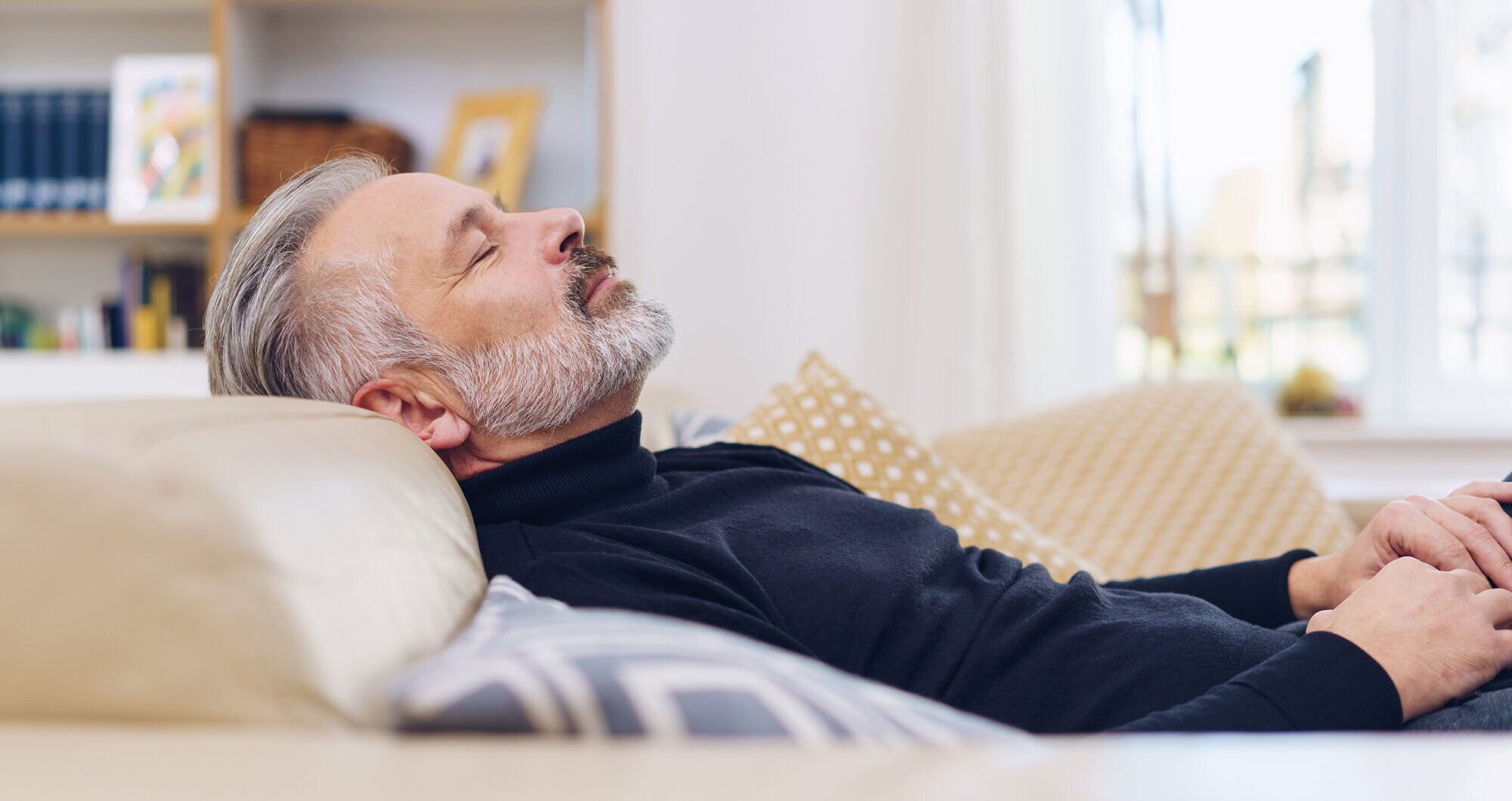 Ein Mann schläft auf einem Sofa.
