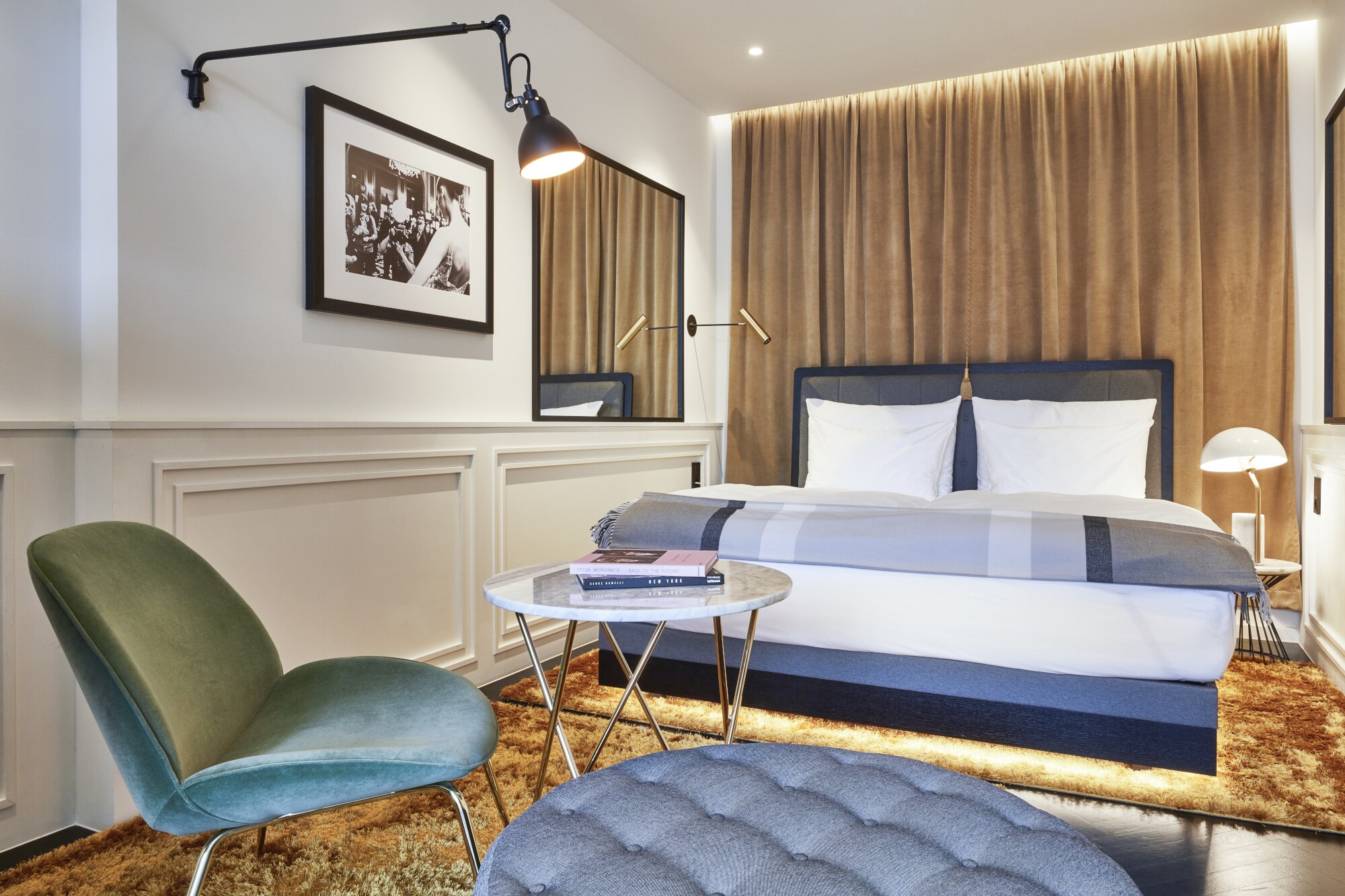 Blick in Hotelzimmer mit Doppelbett, Samtvorhängen und Samtsessel