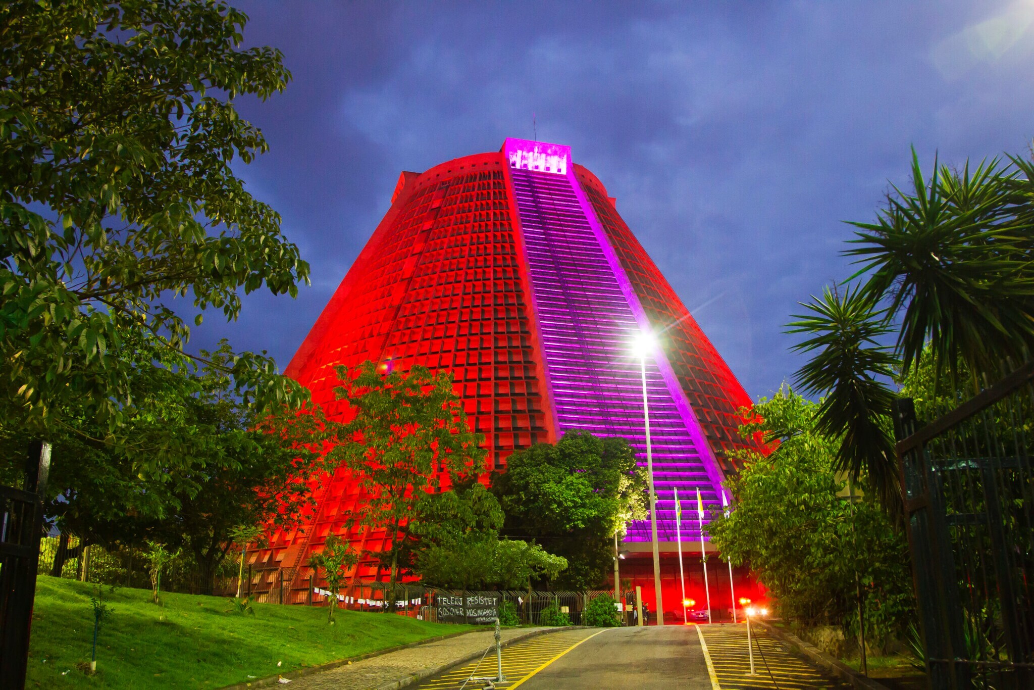 Die Kathedrale von Rio de Janeiro in Pyramidenform mit nächtlicher Außenbeleuchtung in den Farben Rot und Magenta