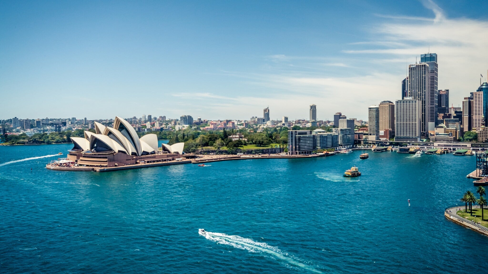 Sydney Opernhaus am Hafen mit Boot auf blauem Wasser und Hochhäusern im Hintergrund Sydney Opernhaus am Hafen mit Boot auf blauem Wasser und Hochhäusern im Hintergrund