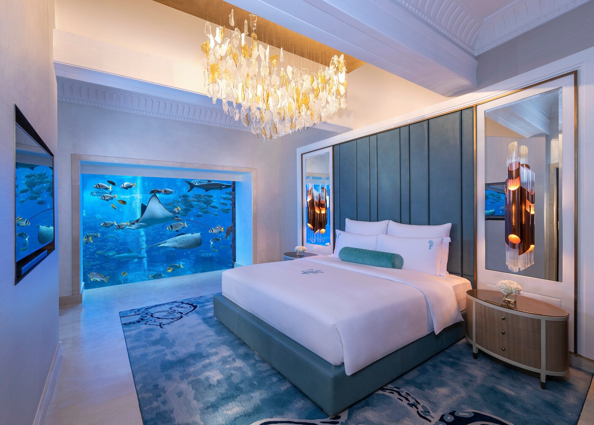 Eine luxuriöse Hotelsuite mit Panoramafenster zu einem Aquarium mit Fischen