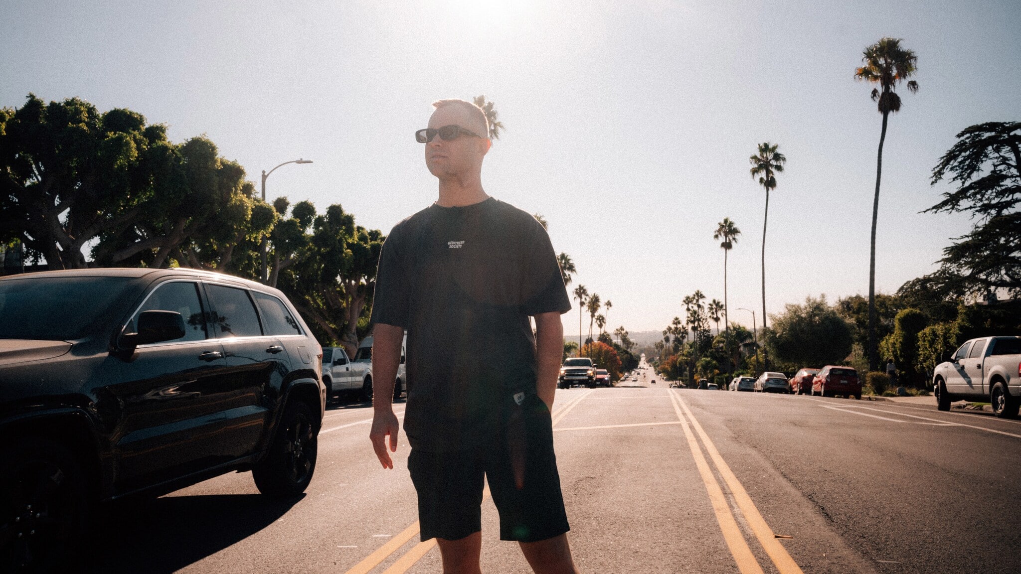 Benjamin Diedering posiert mit Sonnenbrille auf einer palmengesäumten Straße bei Sonnenschein. Benjamin Diedering posiert mit Sonnenbrille auf einer palmengesäumten Straße bei Sonnenschein.