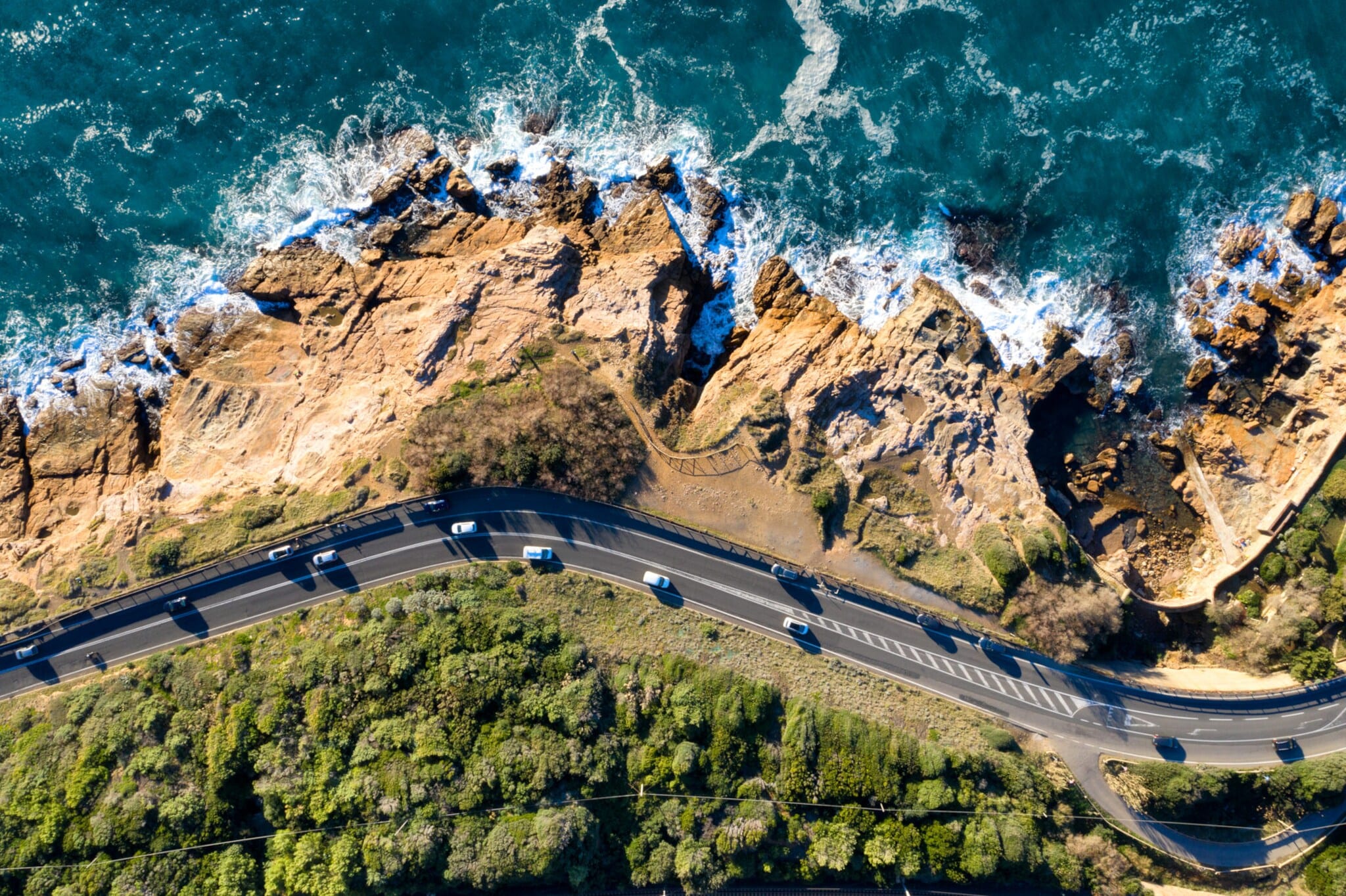 Autos auf einer Straße an einer Felsküste aus der Vogelperspektive. Autos auf einer Straße an einer Felsküste aus der Vogelperspektive.