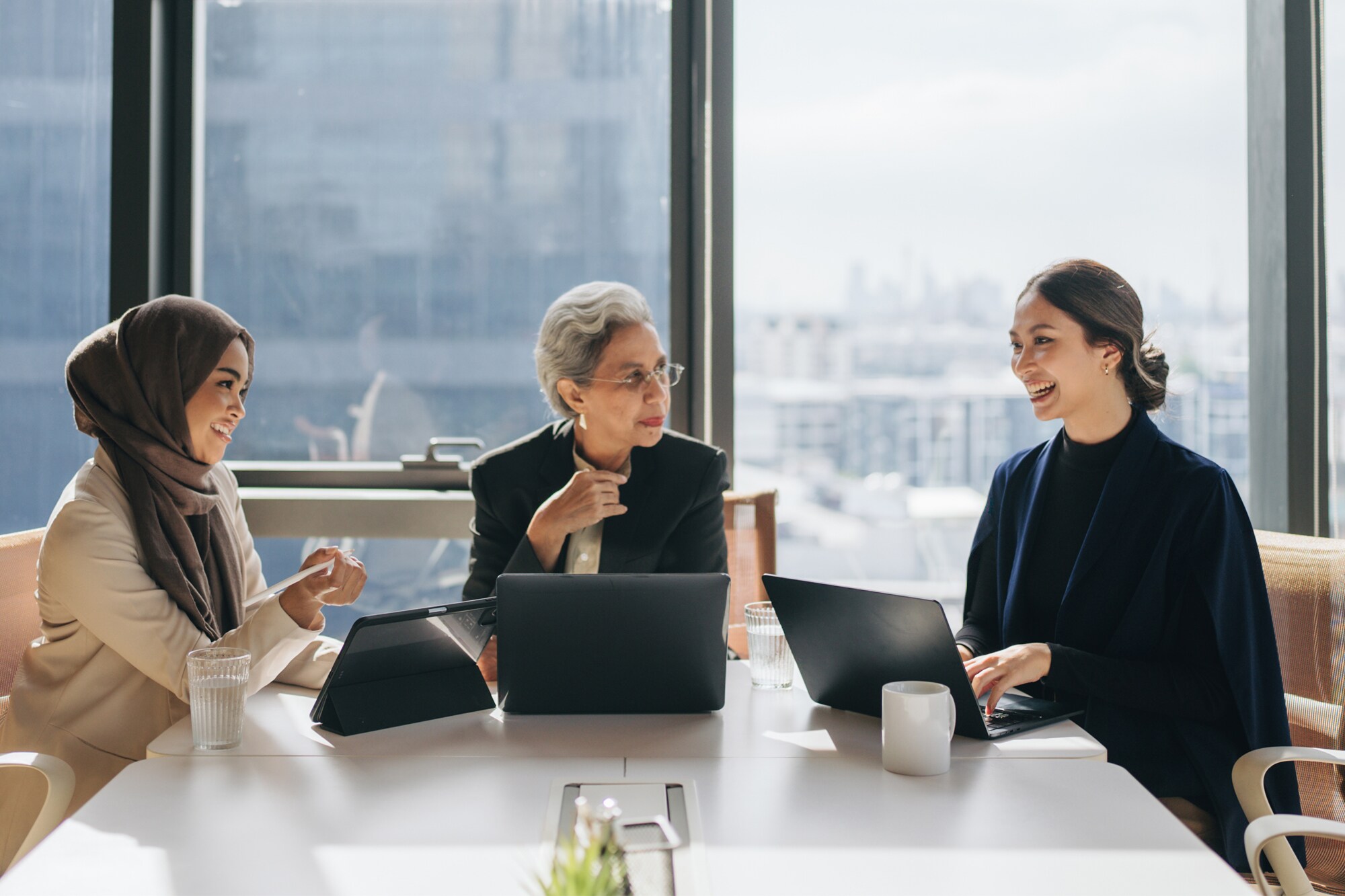 Frauen in der Geschäftsleitung: 5 Erfolgsbeispiele für Female Leadership Teamgeist: Eine Gruppe von Frauen verschiedener Altersgruppen tauscht sich in einem hellen Meetingraum aus.