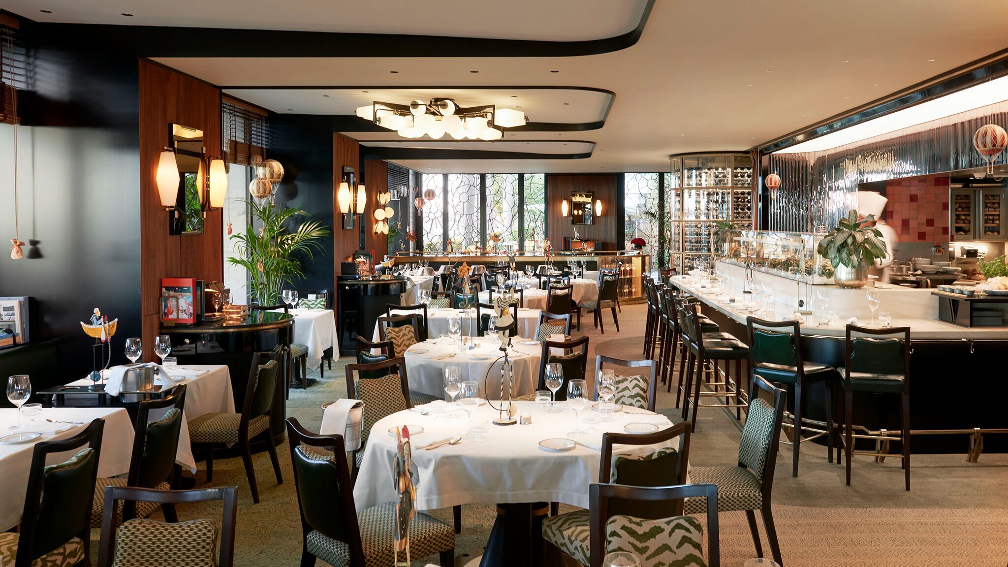 Edler Speisesaal mit eingedeckten Tischen und Barbereich in einem Luxusrestaurant.