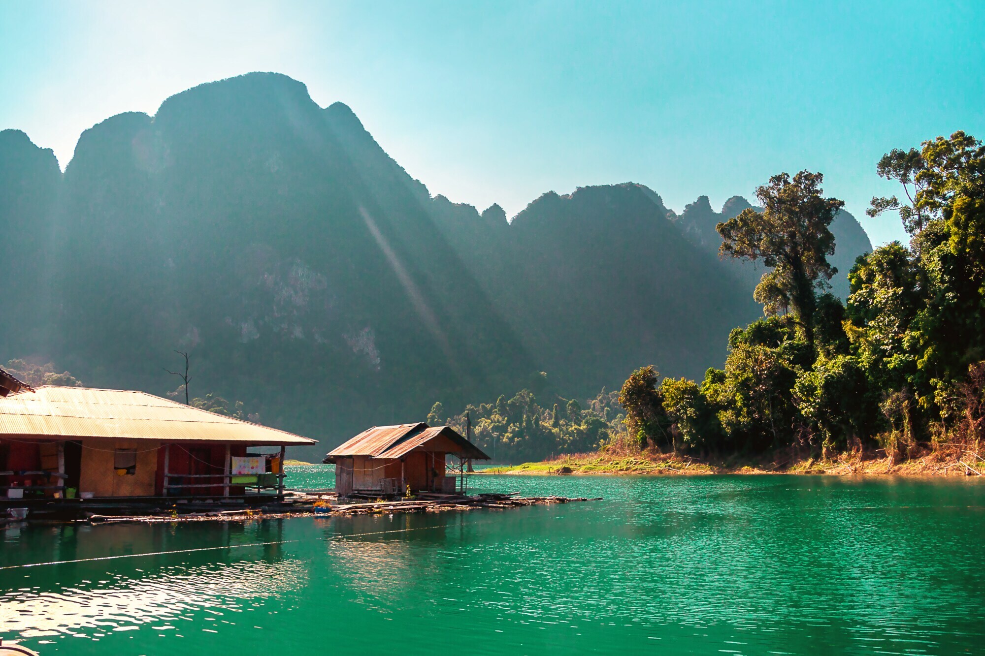 Floßhäuser schwimmen auf dem Cheo-Lan-See, im Hintergrund Berge. Khao Sok Nationalpark, Khao Lak.