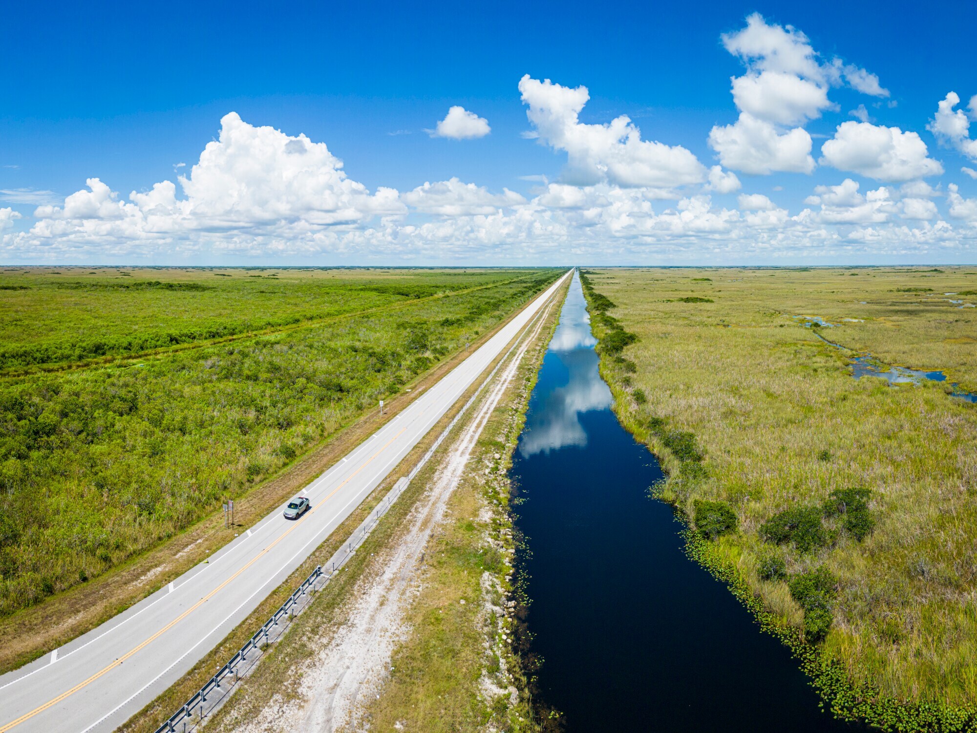 Ein Auto fährt auf einer Straße entlang eines Sumpfes durch den Everglades-Nationalpark.