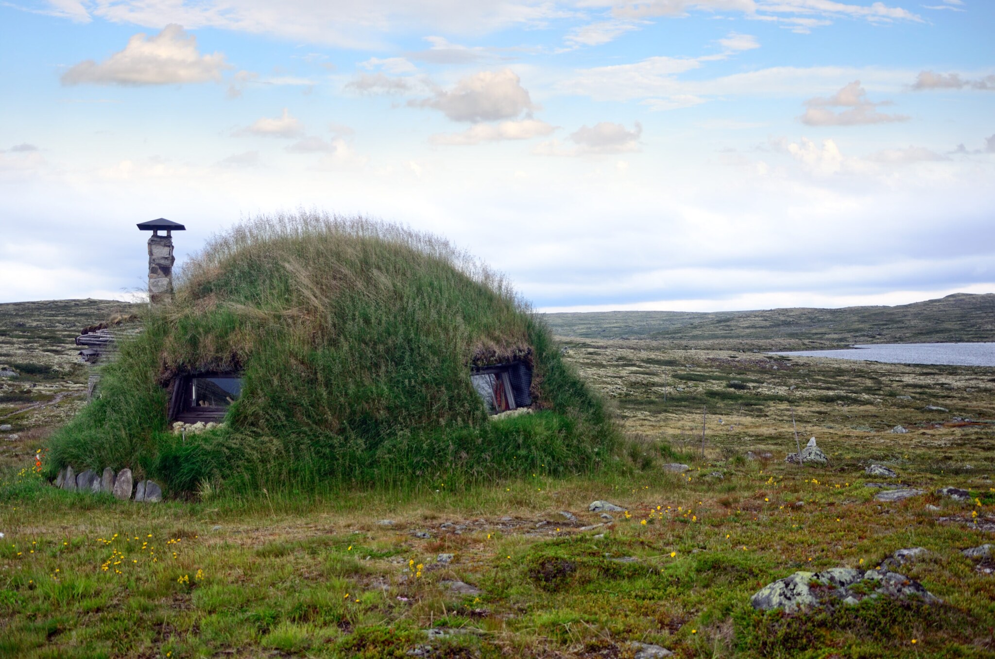 Ein Erdhaus aus Grasboden mit Fenstern und Schornstein in der Tundra