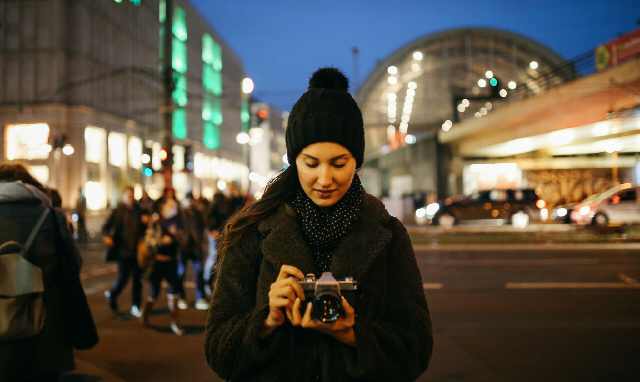 Eine Frau hält eine Kamera in der Hand und schaut auf das Display