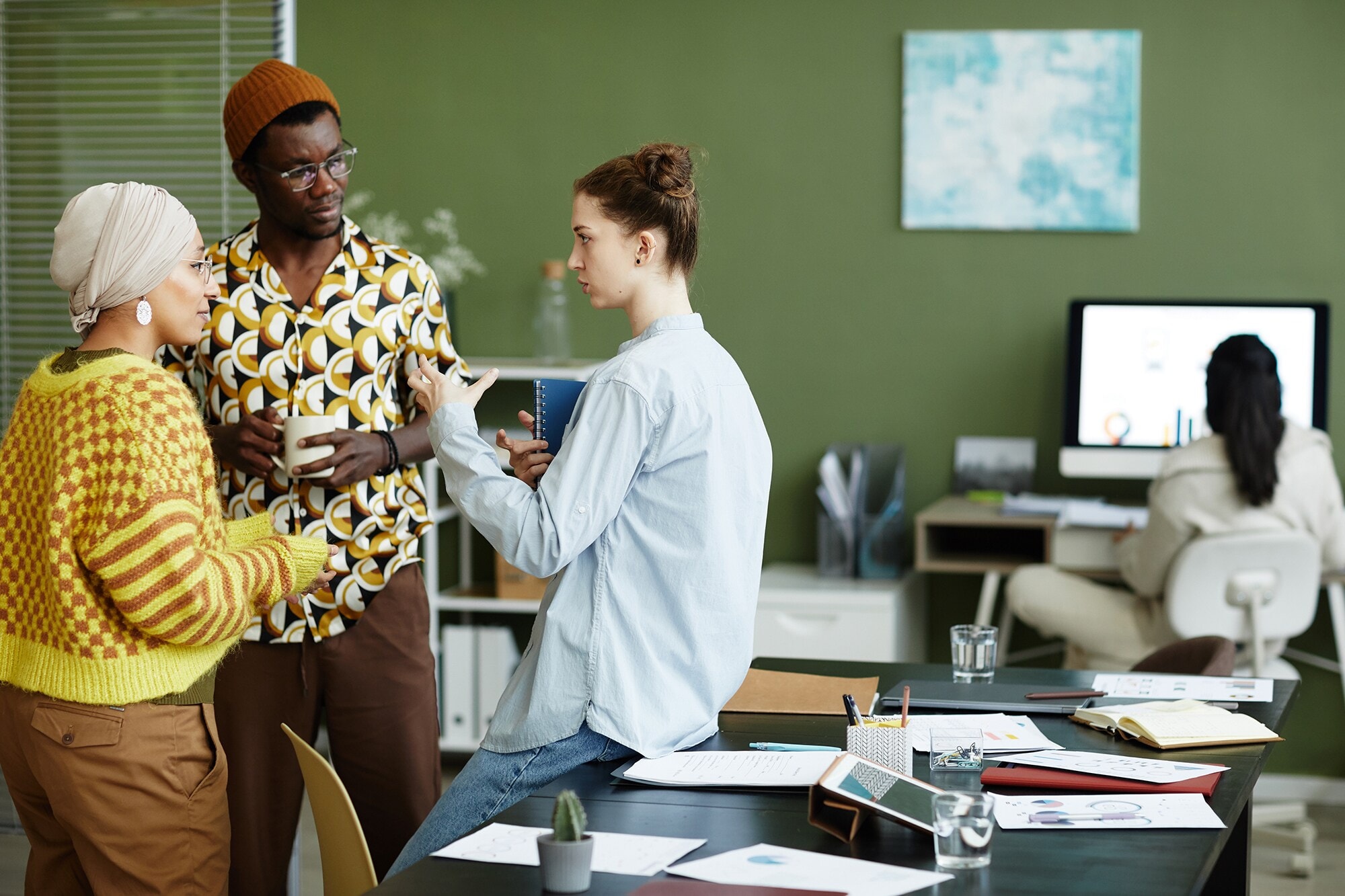 Büro einrichten: 7 Tipps für die perfekte Arbeitsatmosphäre Waist up portrait of three creative young people discussing work in office and gesturing, copy space