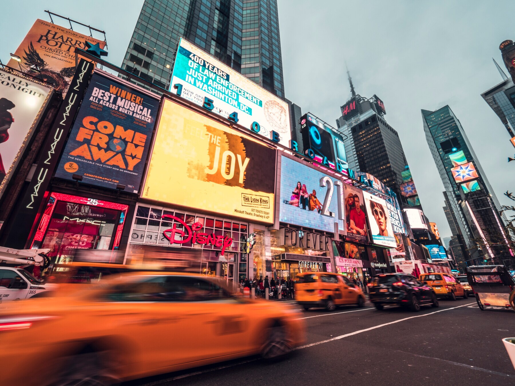 Times Square mit Leuchtreklame und vorbeifahrenden gelben Taxis Times Square mit Leuchtreklame und vorbeifahrenden gelben Taxis