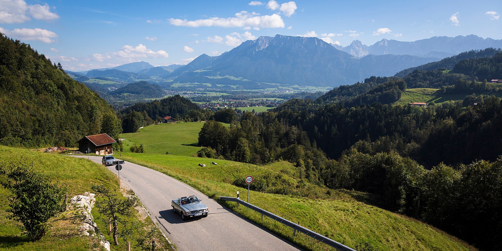 Ein Cabriolet auf einer Straße in den Alpen.