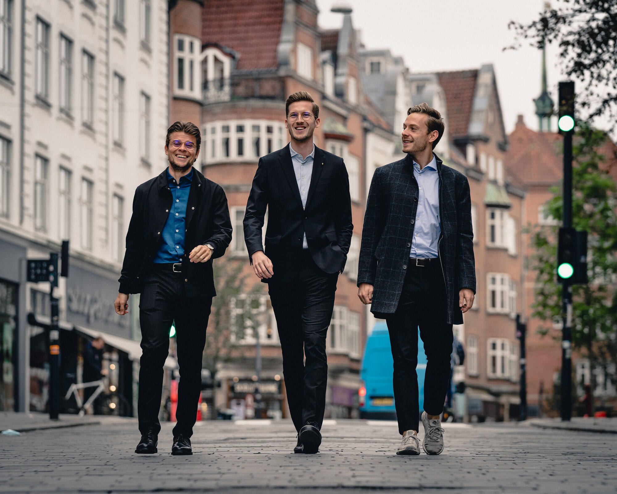 Die Gründer von Shaping New Tomorrow Christoffer Bak, Kasper Ulrich und Christian Aachmann laufen durch eine Stadt