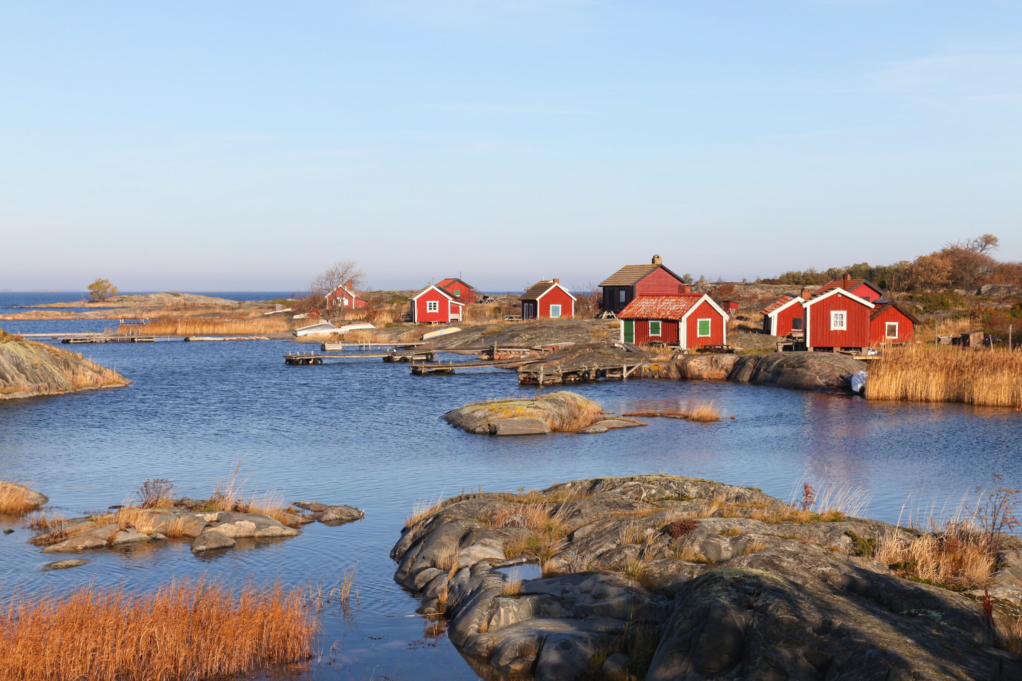 Blick auf rote Holzhäuser auf einer Insel.