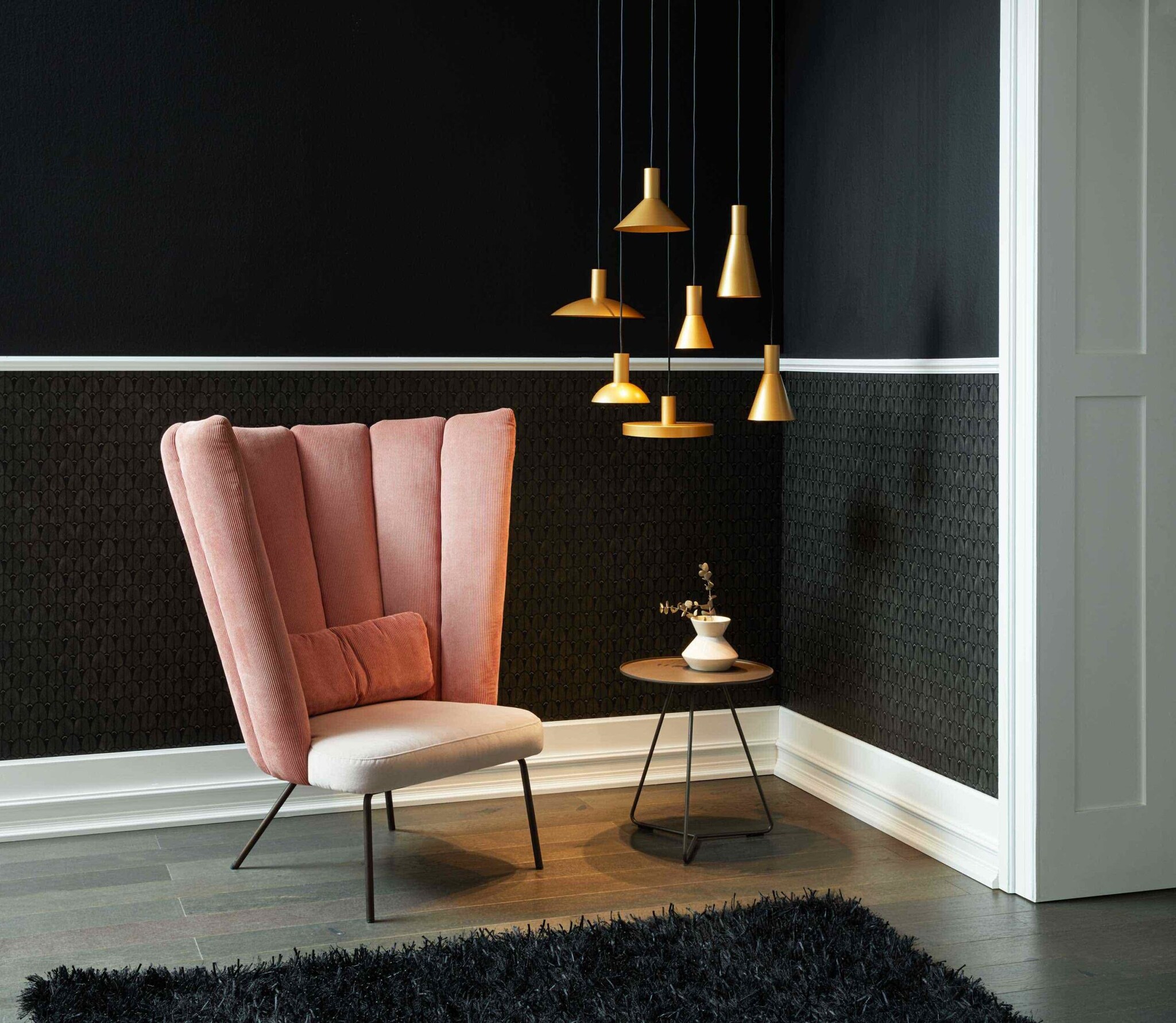 Mehrere kleine Designer-Pendelleuchten erhellen einen kleinen Beistelltisch. Mehrere kleine Designer-Pendelleuchten erhellen einen kleinen Beistelltisch.