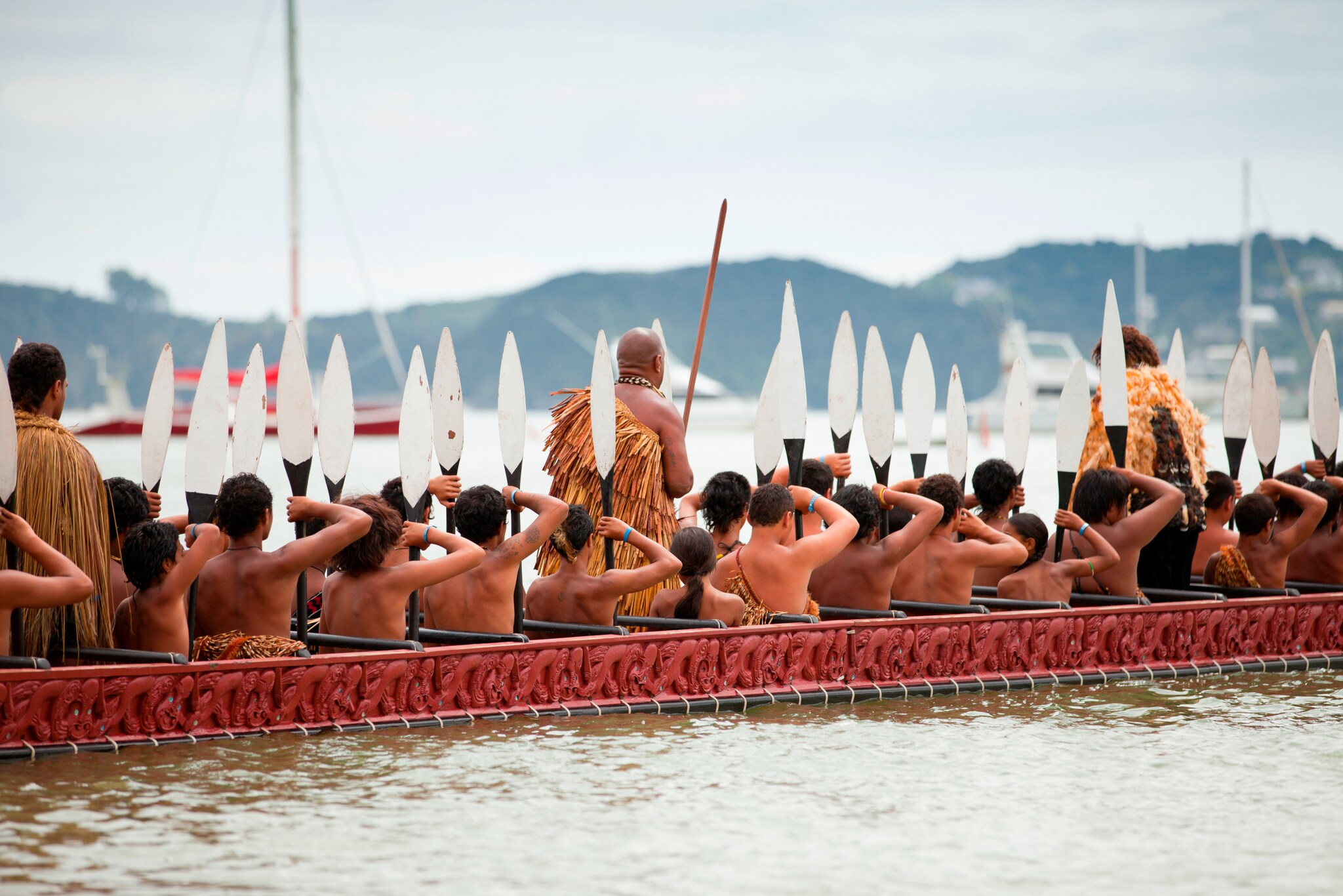 Menschen in traditioneller Kleidung auf einem Boot.