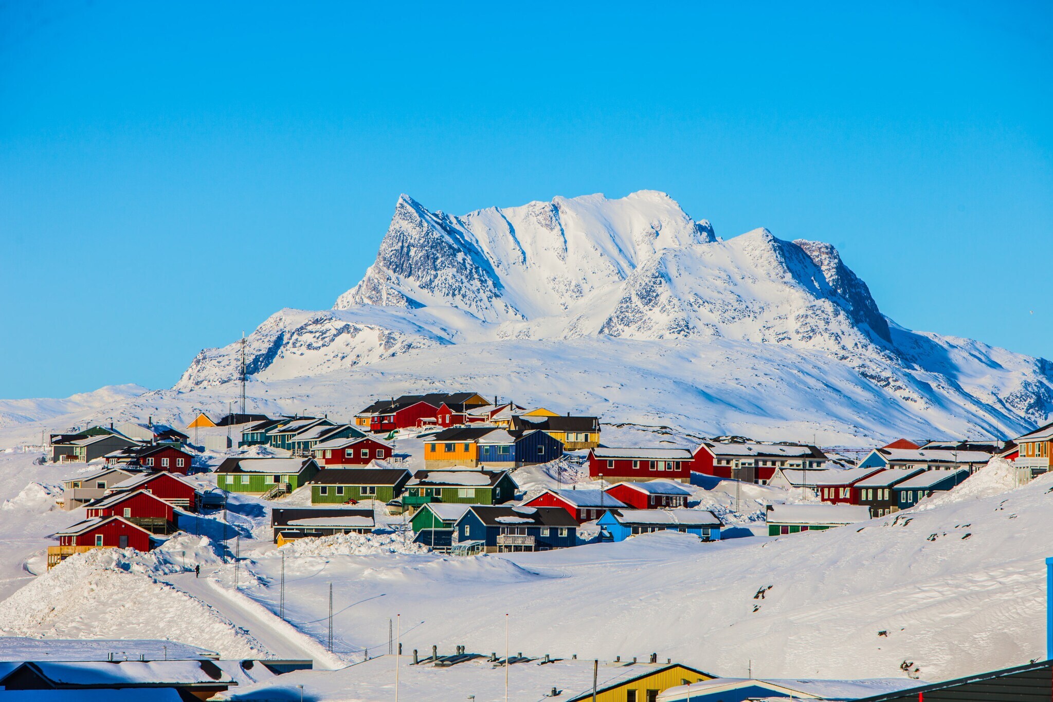 Schneebedeckte Landschaft und farbige Häuser in Nuuk mit dem Breg Sermitsiaq im Hintergrund. Schneebedeckte Landschaft und farbige Häuser in Nuuk mit dem Breg Sermitsiaq im Hintergrund.