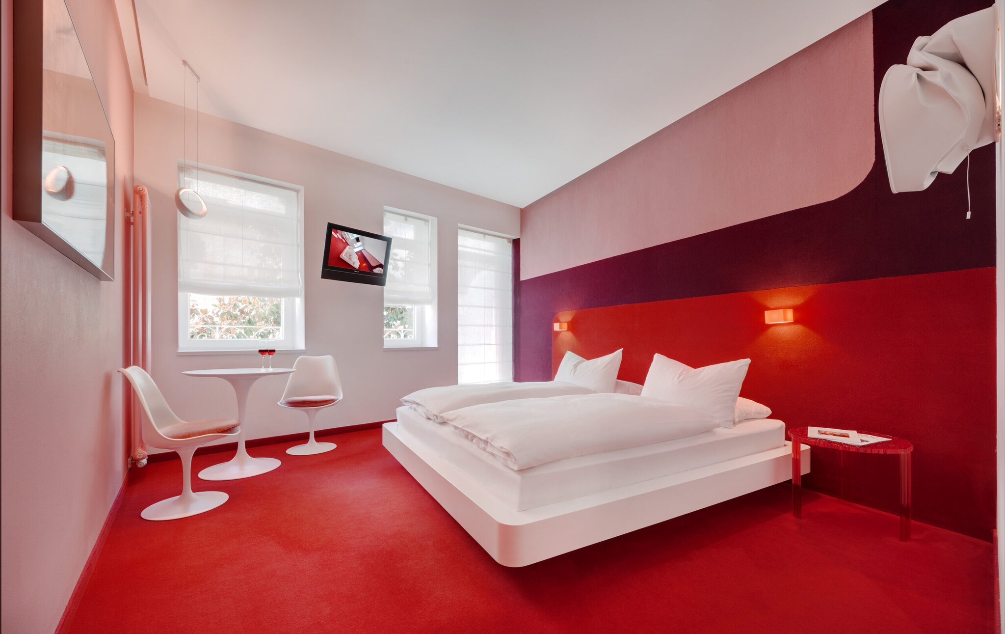 Innenansicht eines Hotelzimmers mit rotem Teppich