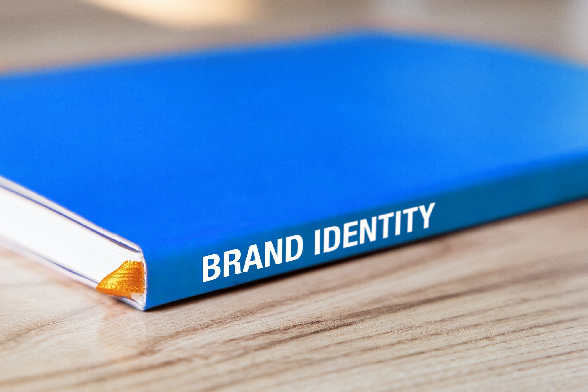Brandbook Basics: Schritt für Schritt Ein blaues Buch mit der Aufschrift "Brand Identity" liegt auf dem Tisch.