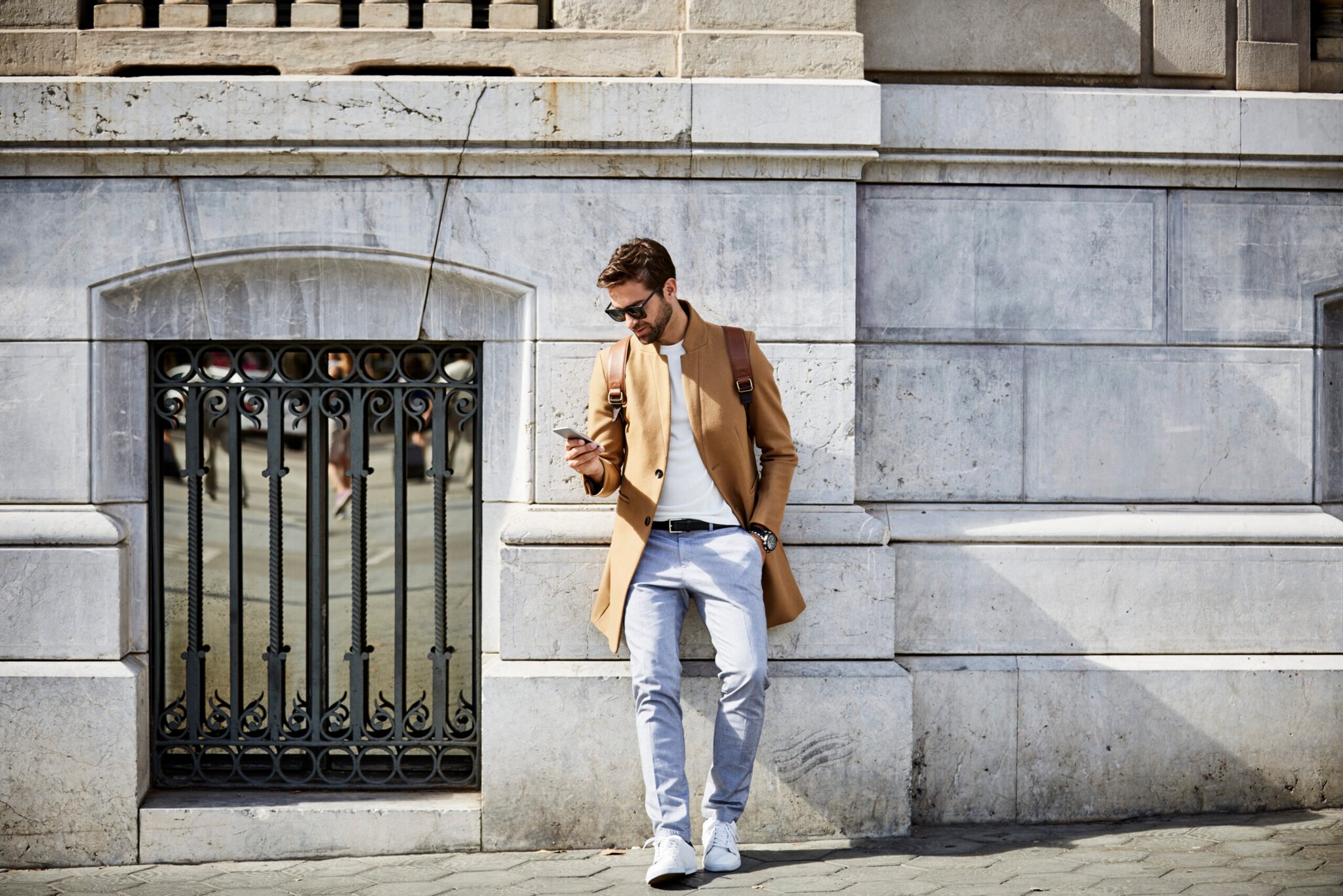 Mann mit Smartphone vor einem Gebäude