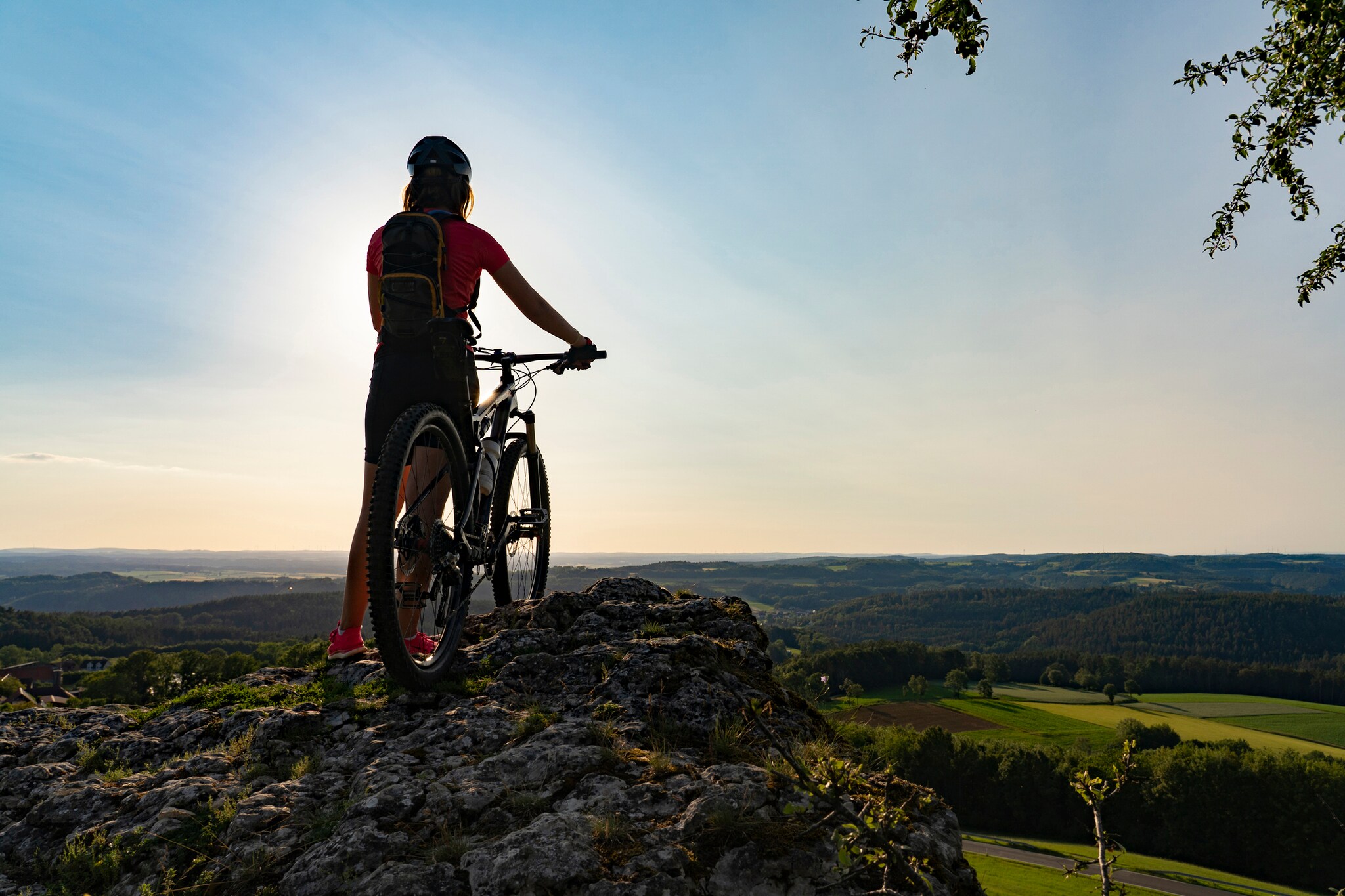 Ein Frau mit Mountainbike an einem Aussichtspunkt in der Fränkischen Schweiz