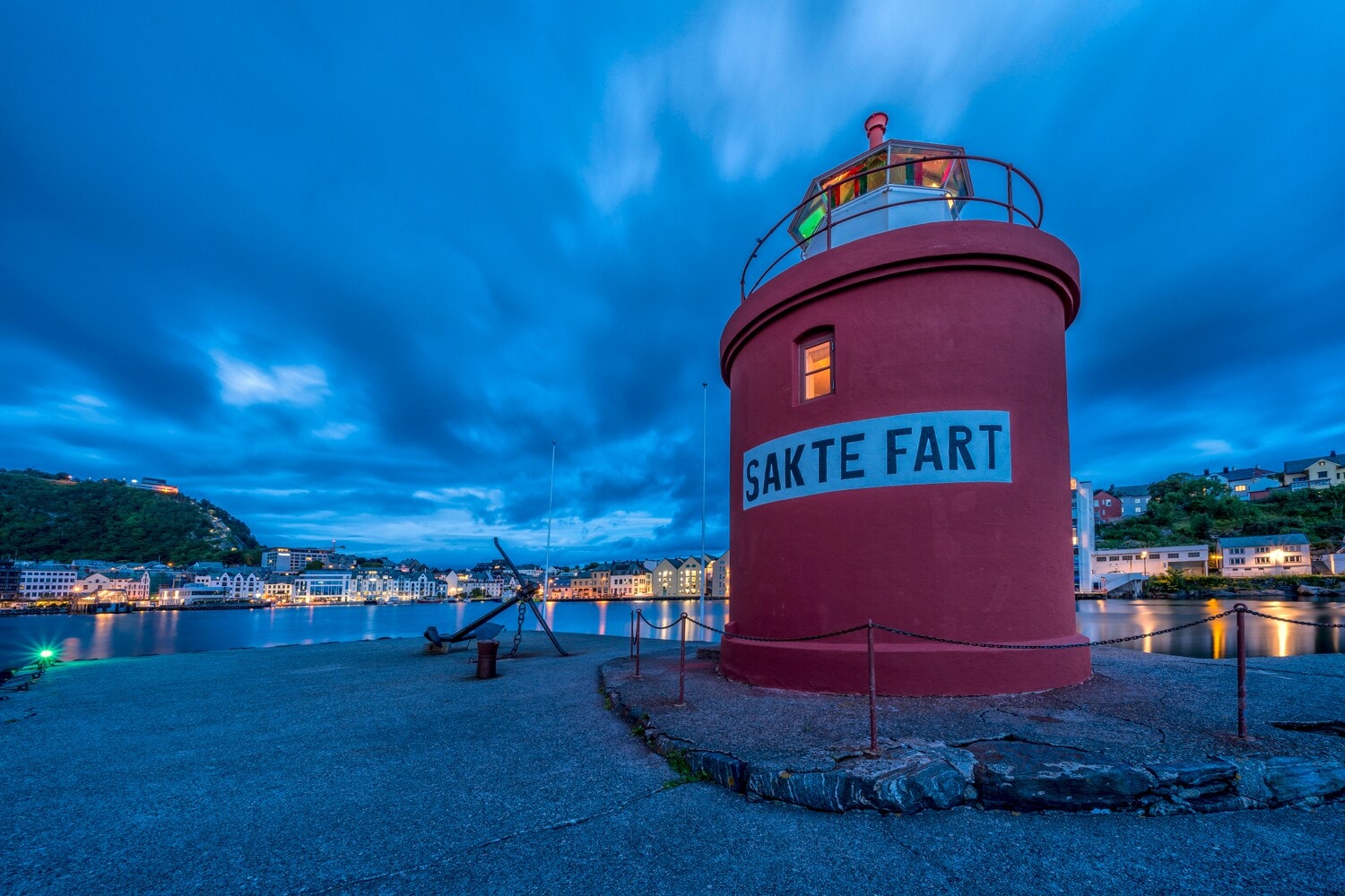 Ein eingeschossiger roter Leuchtturm direkt an der Mole der norwegischen Hafenstadt Ålesund Ein eingeschossiger roter Leuchtturm direkt an der Mole der norwegischen Hafenstadt Ålesund