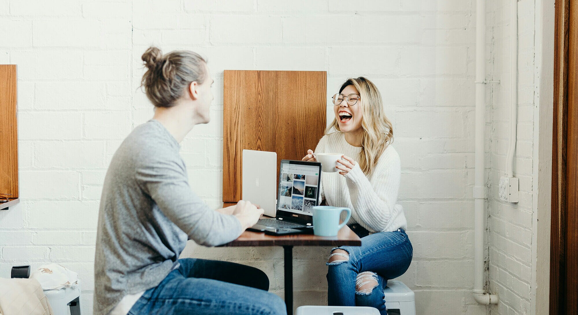 Zwei Kolleg:innen freuen sich gemeinsam während der Arbeit